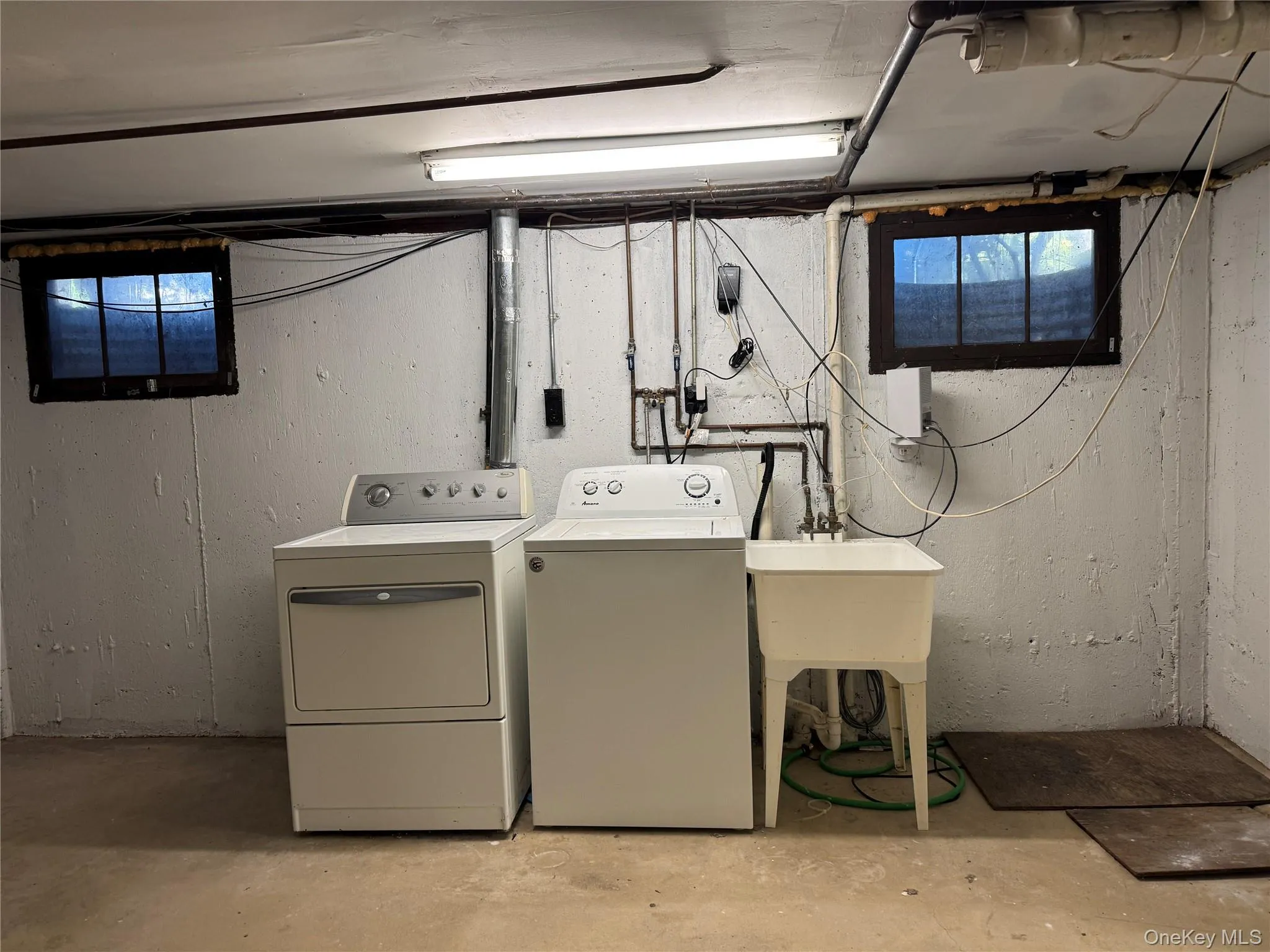 Laundry area with unfinished concrete flooring and washer and dryer Laundry area with unfinished concrete flooring and washer and dryer