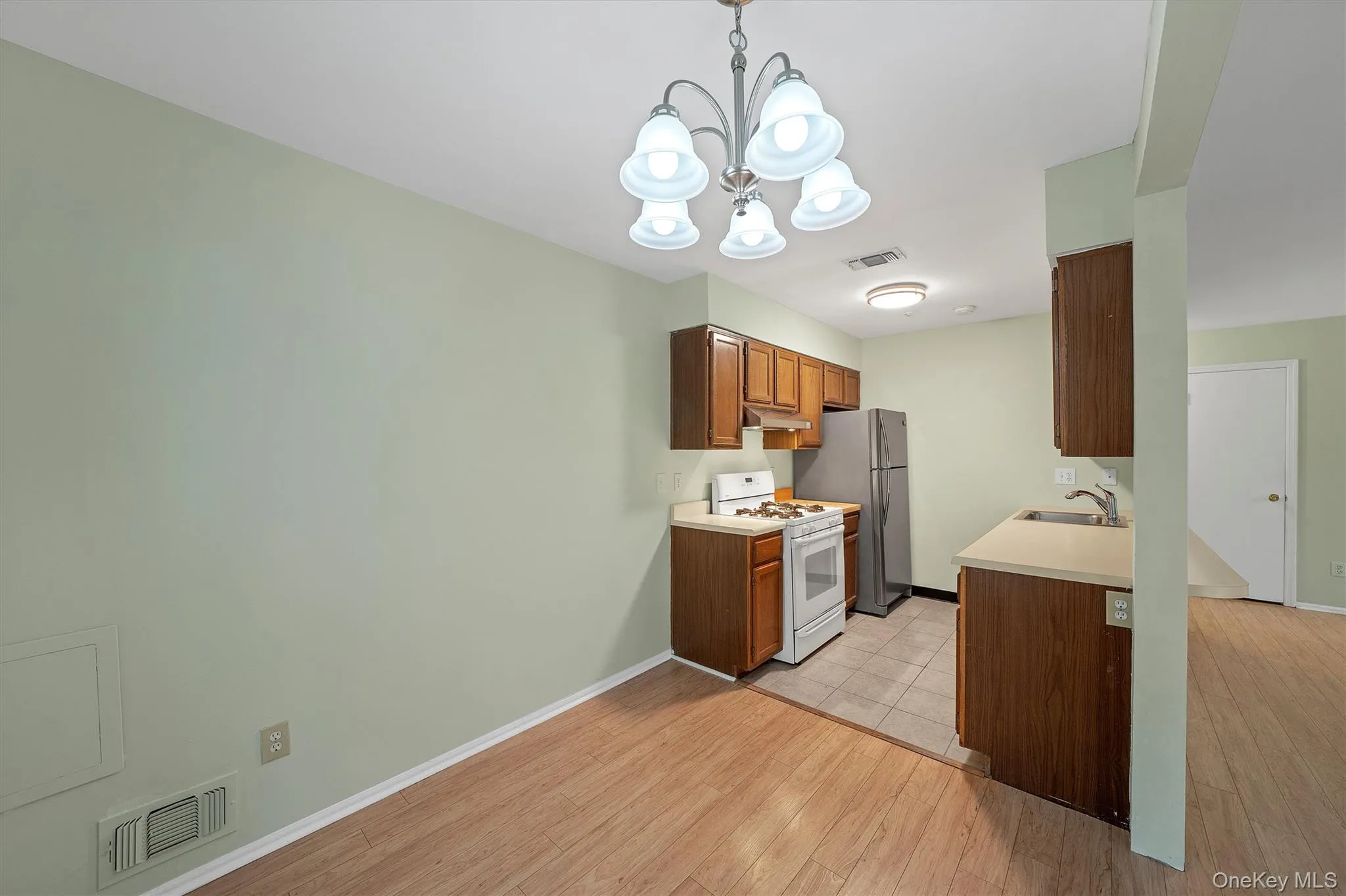 Kitchen with white range with gas stovetop, light countertops, light wood-type flooring Kitchen with white range with gas stovetop, light countertops, light wood-type flooring