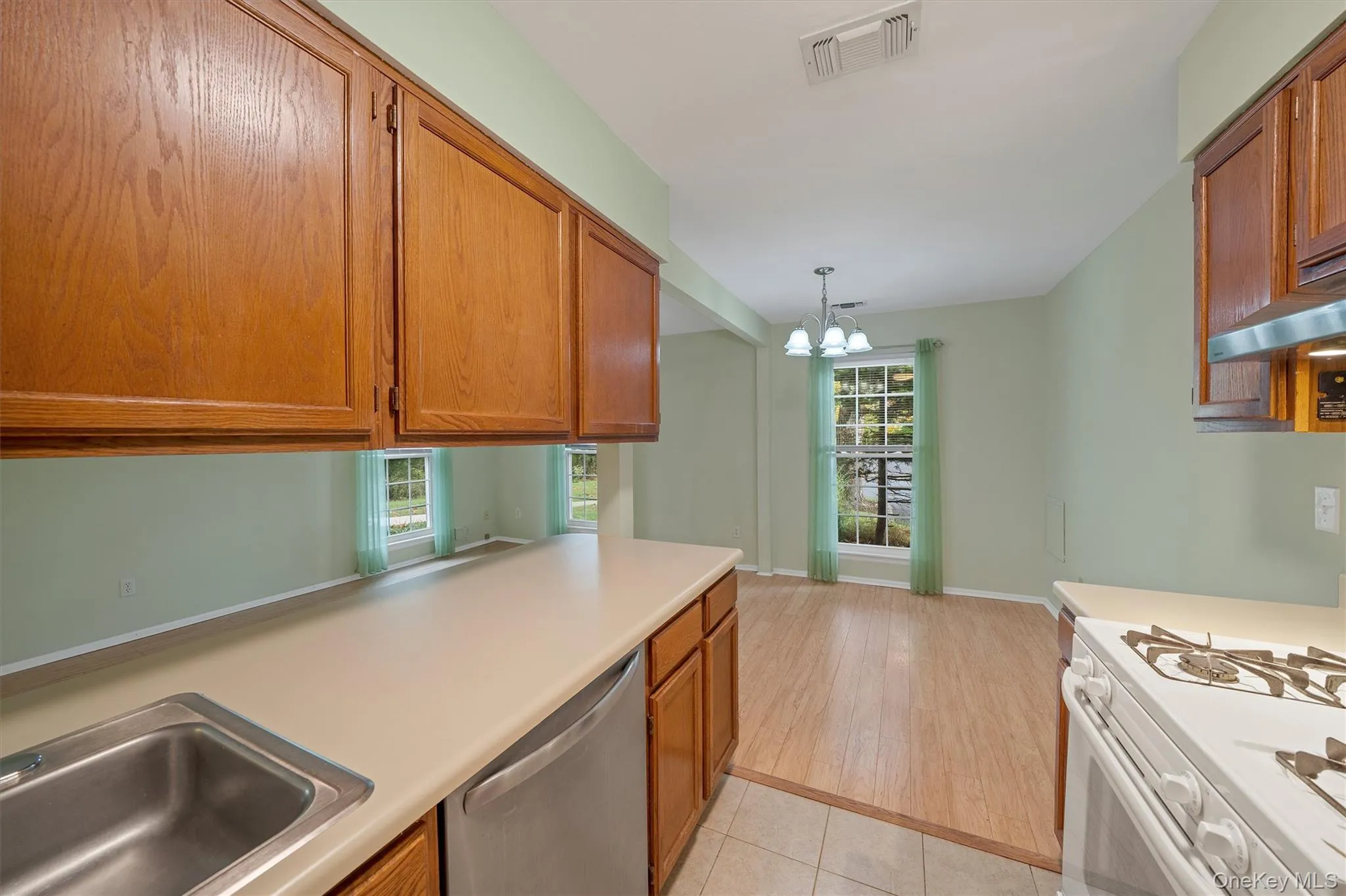 Kitchen with dishwasher, healthy amount of natural light, and wood cabinets Kitchen with dishwasher, healthy amount of natural light, and wood cabinets