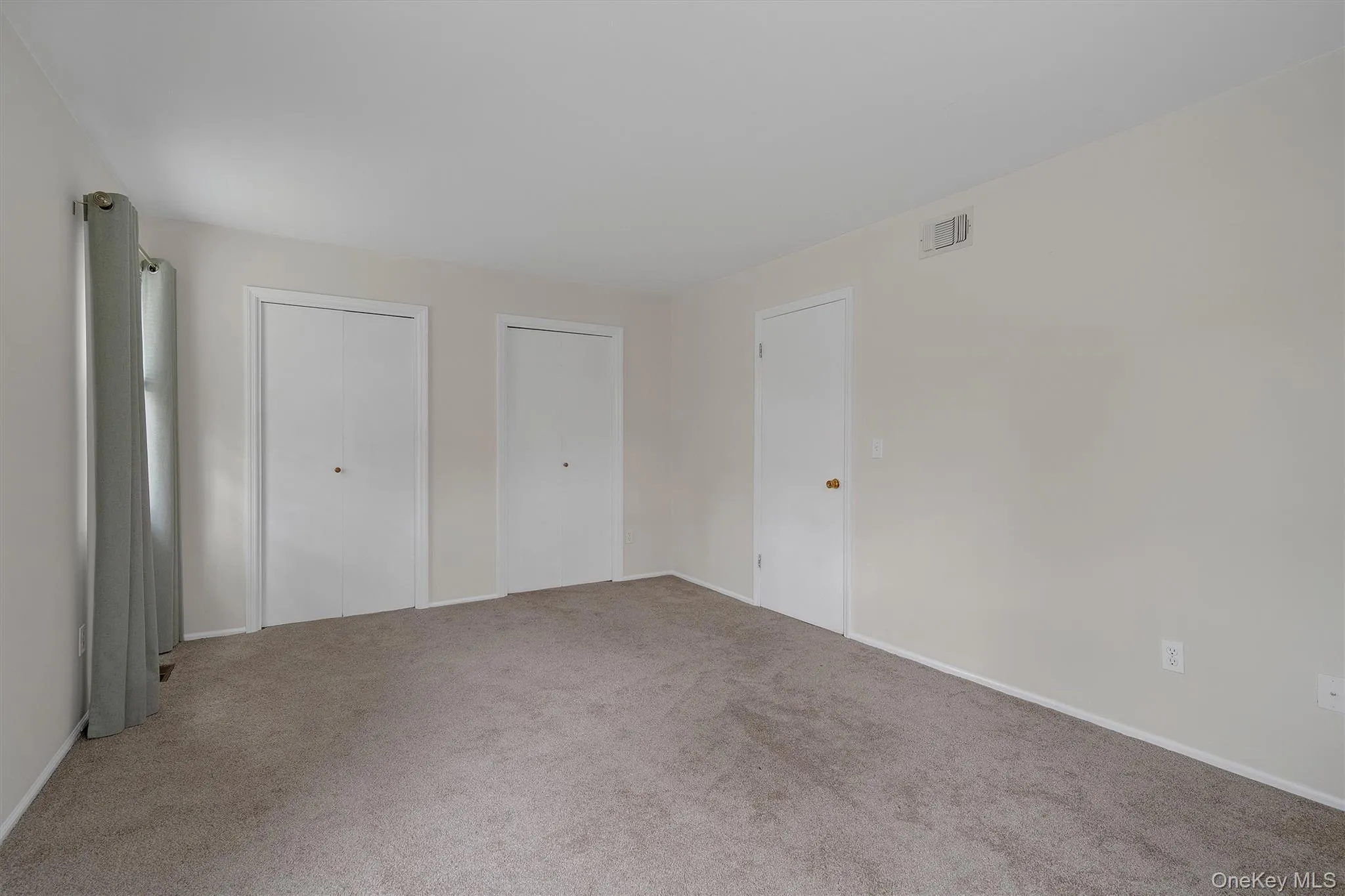 bedroom featuring two closets and carpet bedroom featuring two closets and carpet
