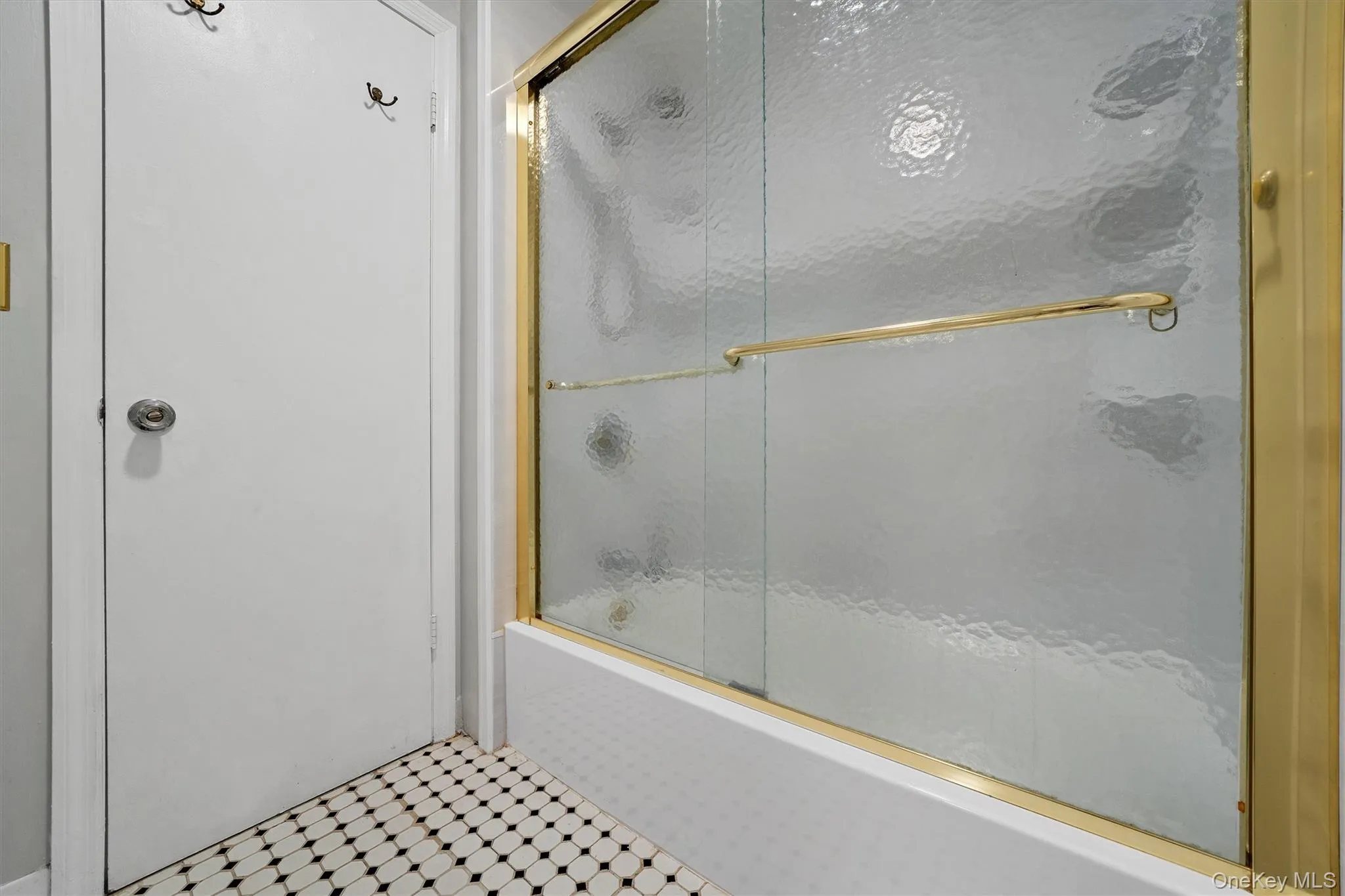 Full bathroom featuring bath / shower combo with glass door Full bathroom featuring bath / shower combo with glass door