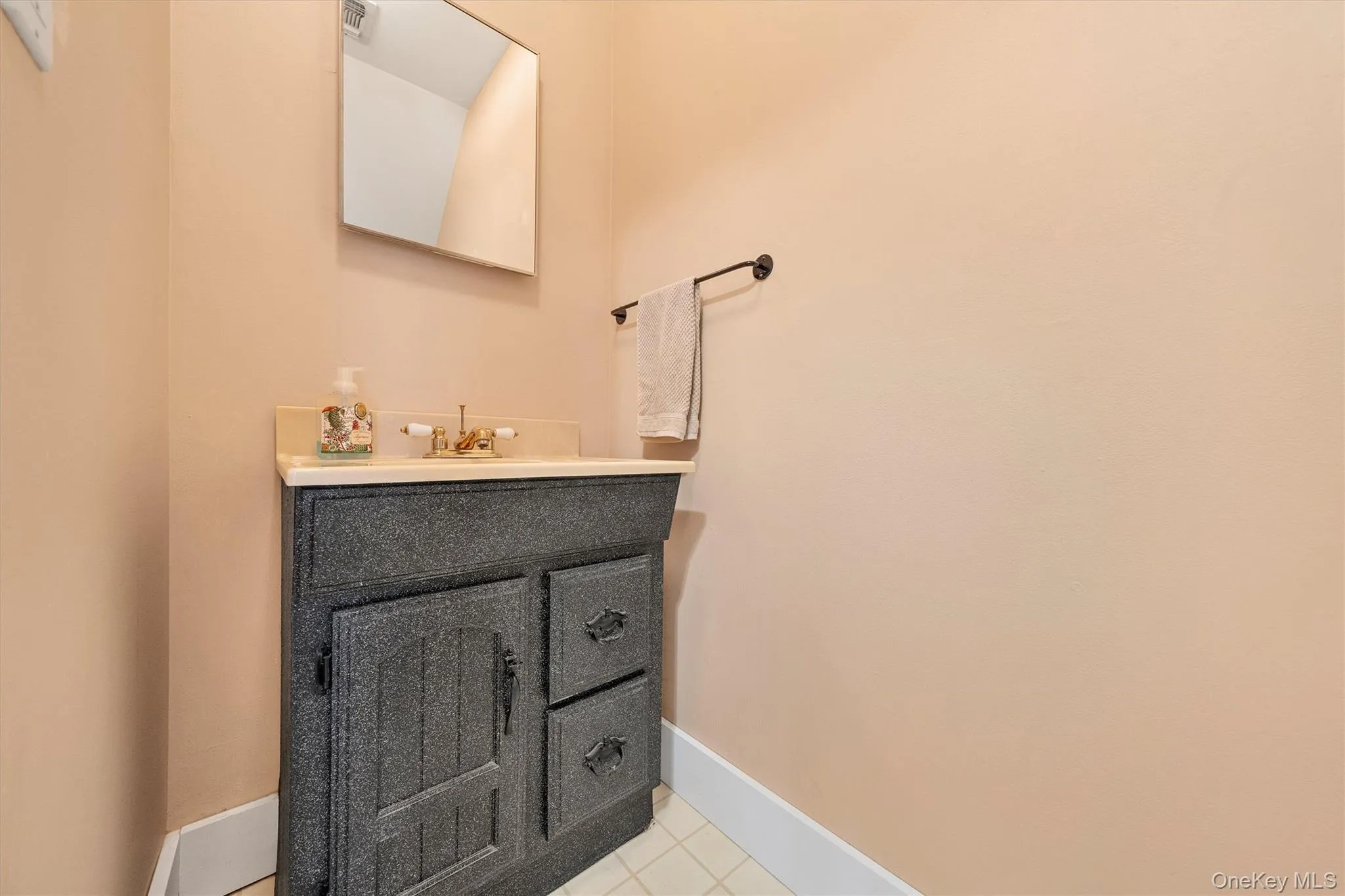 half bathroom featuring vanity and light tile patterned flooring half bathroom featuring vanity and light tile patterned flooring