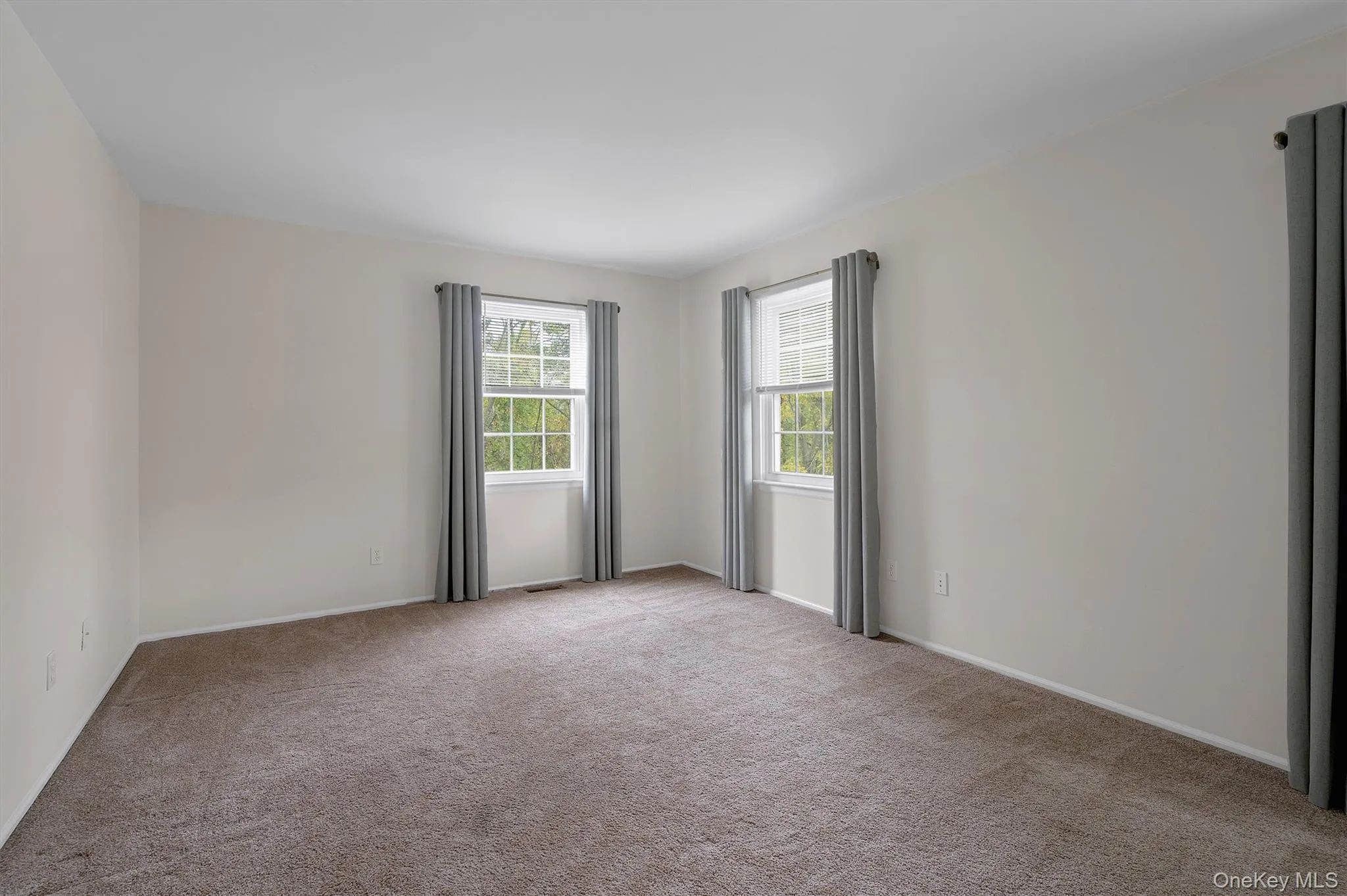 bedroom featuring light carpet and baseboards bedroom featuring light carpet and baseboards