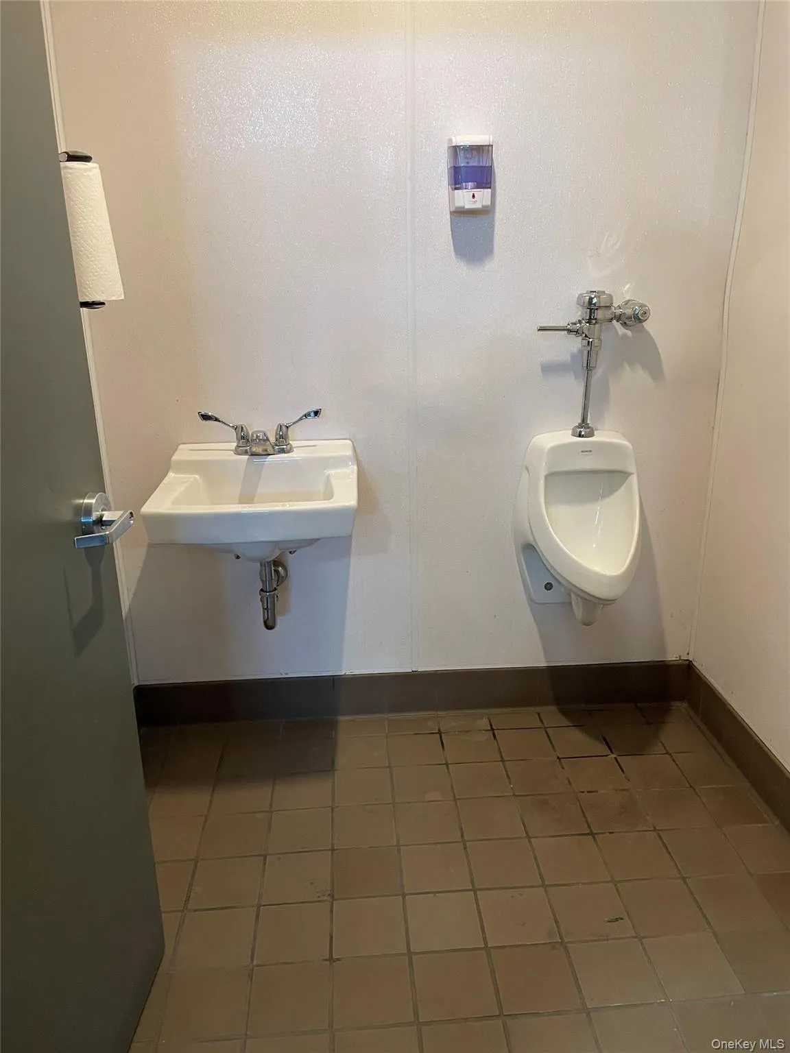Bathroom with dark tile patterned flooring and a sink Bathroom with dark tile patterned flooring and a sink
