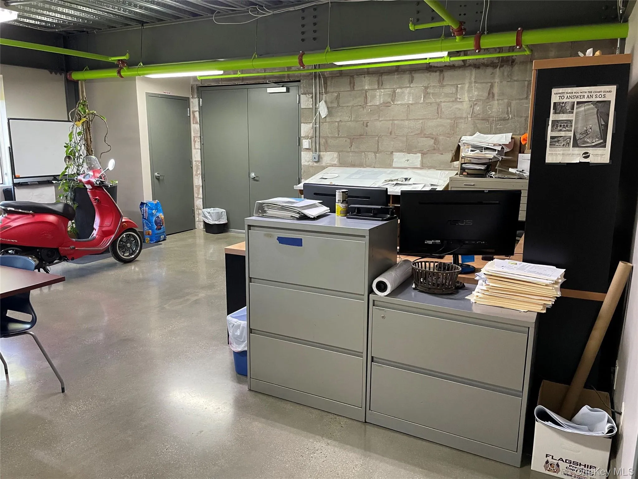 Office area featuring concrete floors and concrete block wall Office area featuring concrete floors and concrete block wall