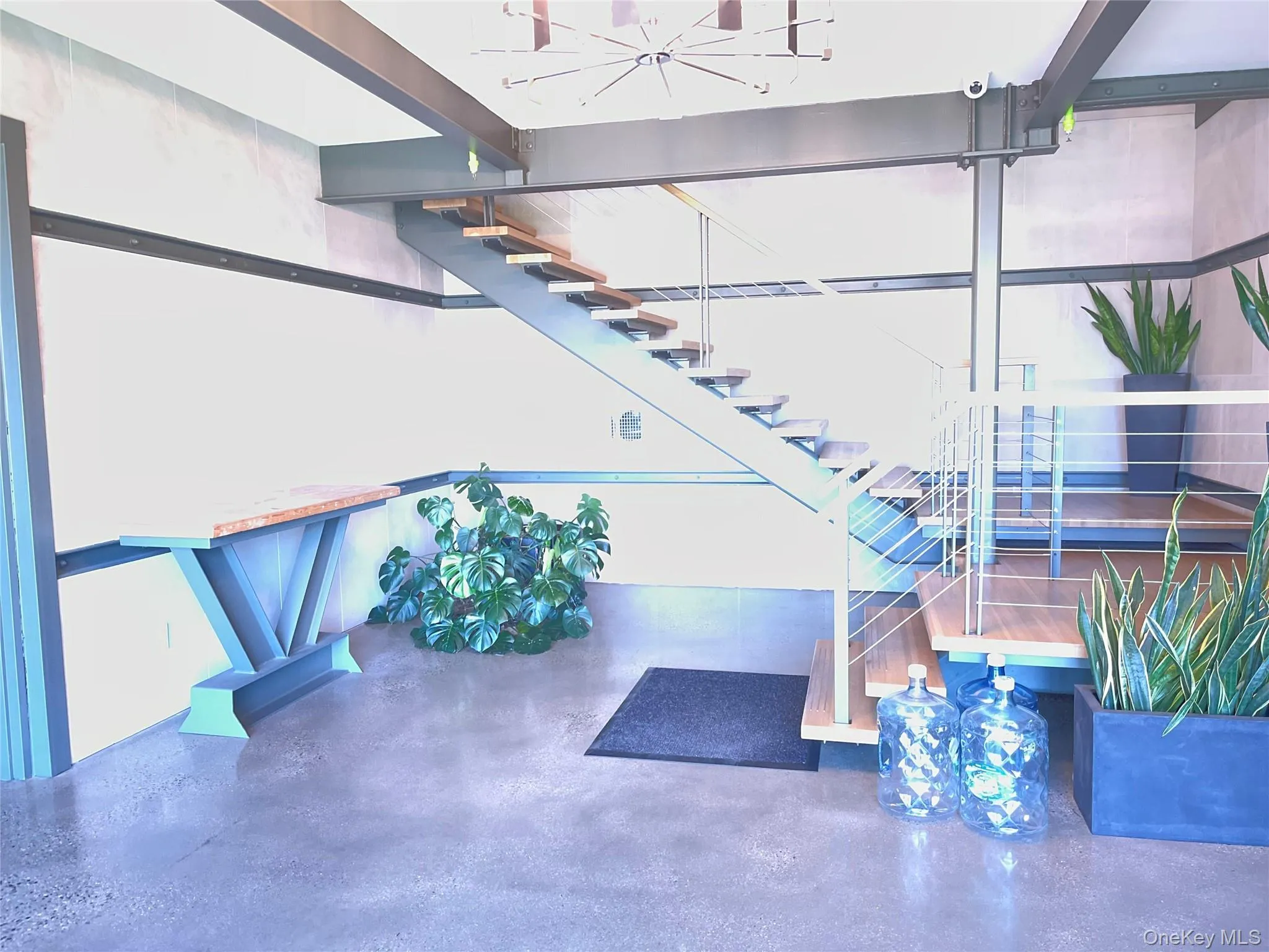 Stairs featuring a chandelier and concrete flooring Stairs featuring a chandelier and concrete flooring