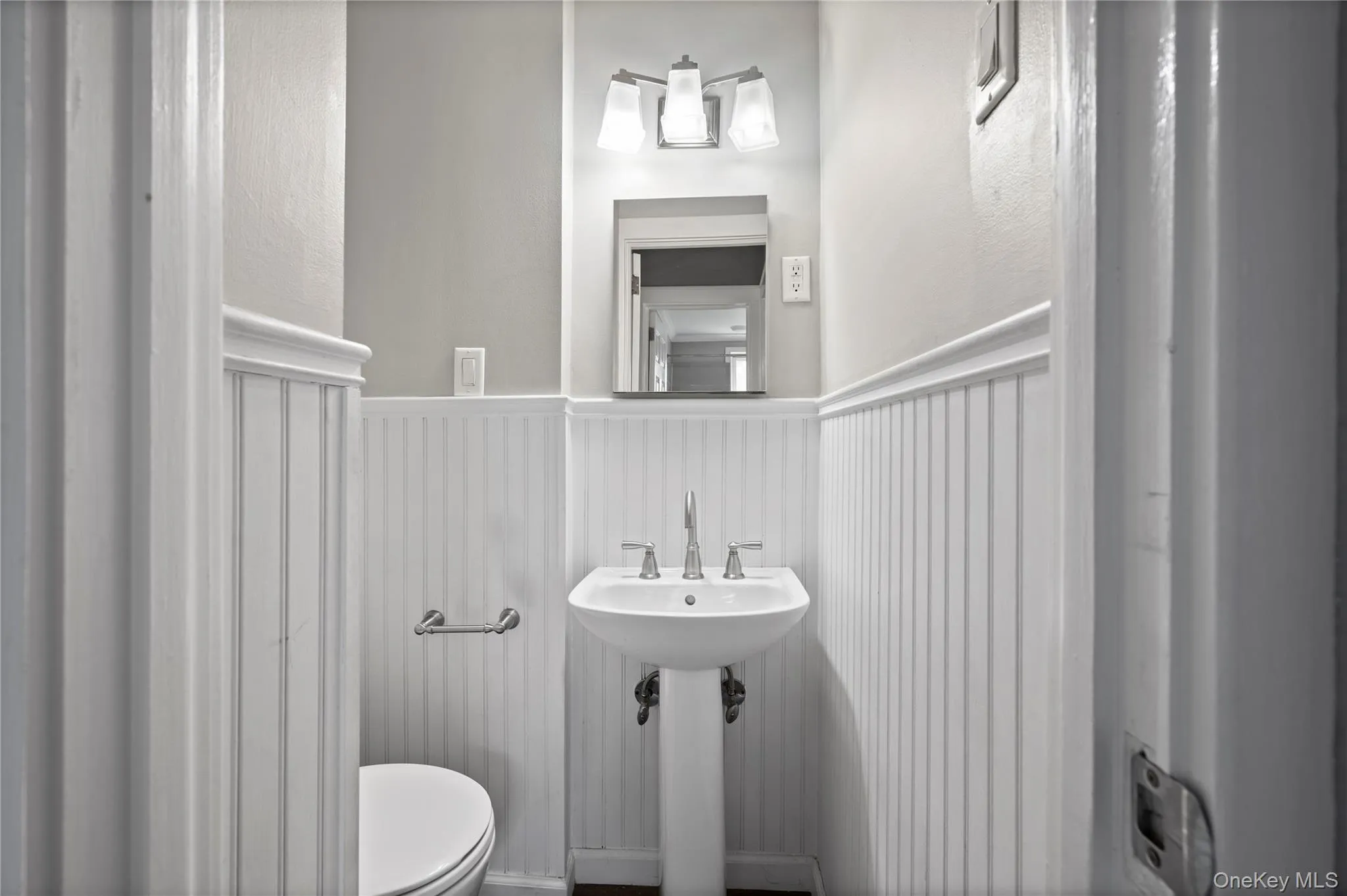 Bathroom with toilet and a wainscoted wall Bathroom with toilet and a wainscoted wall