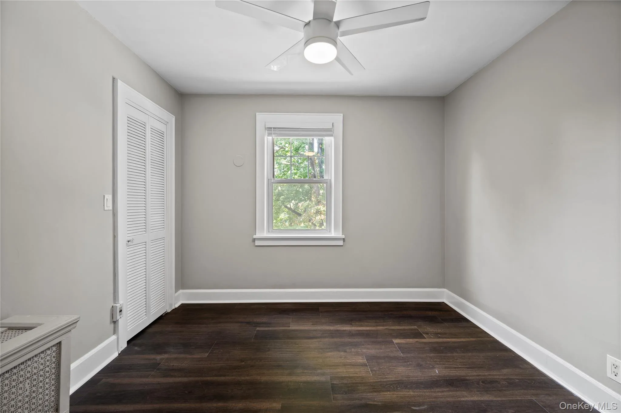 Unfurnished bedroom with dark wood-style floors and ceiling fan Unfurnished bedroom with dark wood-style floors and ceiling fan