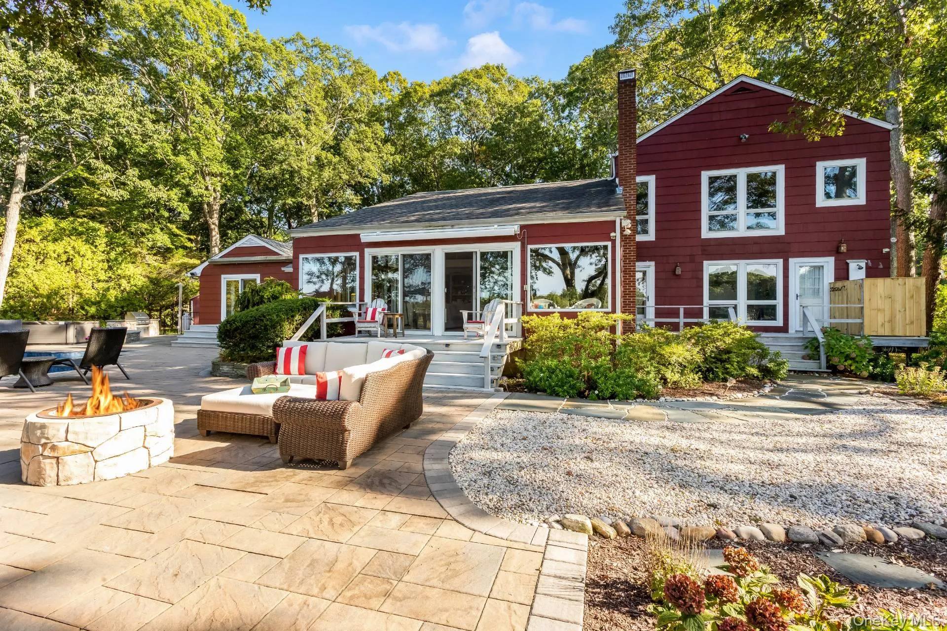 Back of property featuring a chimney, an outdoor living space with a fire pit, and a patio Back of property featuring a chimney, an outdoor living space with a fire pit, and a patio