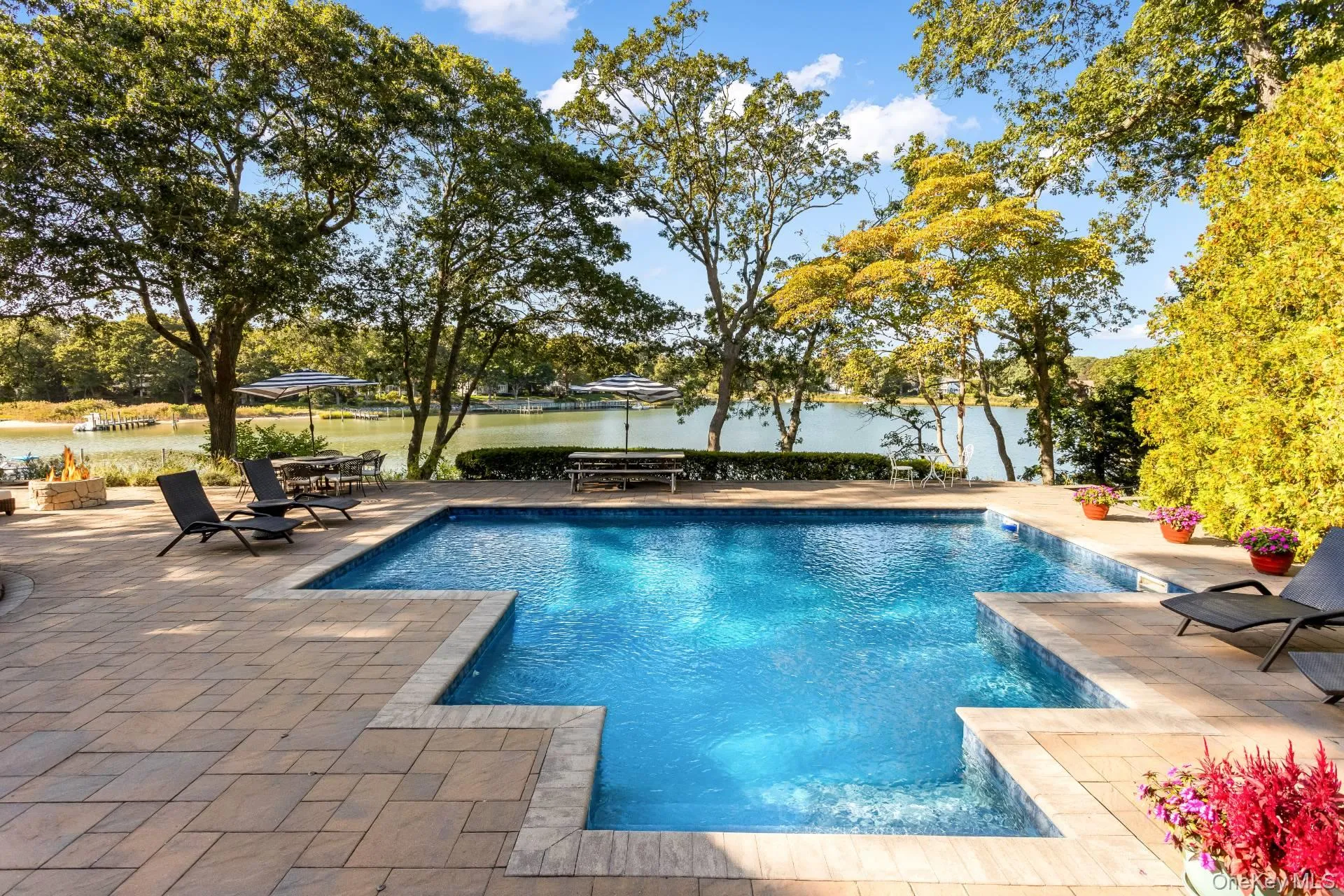 Outdoor pool with a patio and a water view Outdoor pool with a patio and a water view