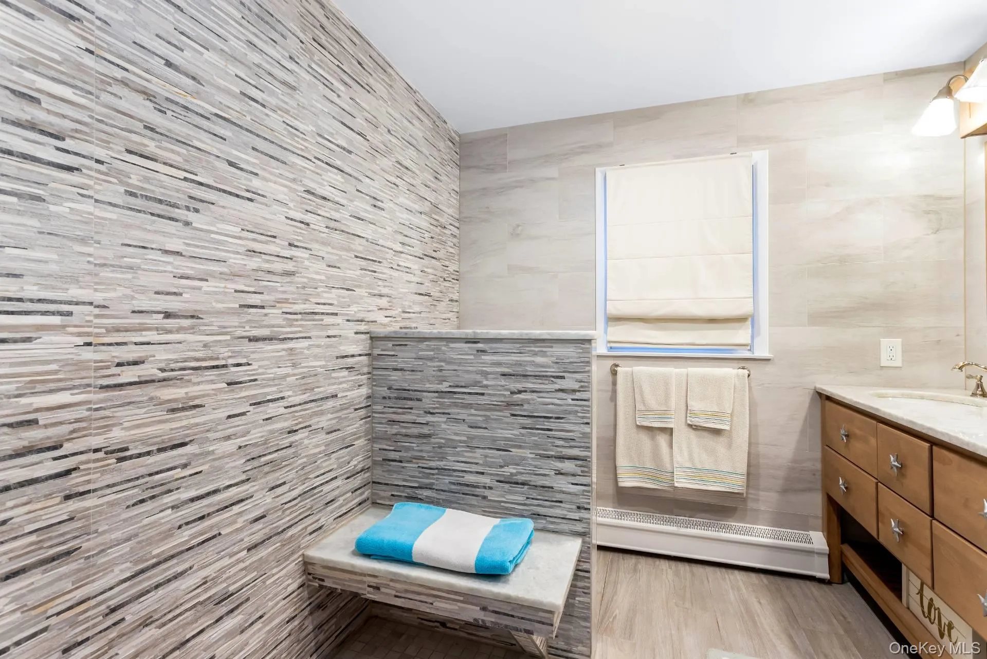 Bathroom with vanity, tile walls, and light wood finished floors Bathroom with vanity, tile walls, and light wood finished floors