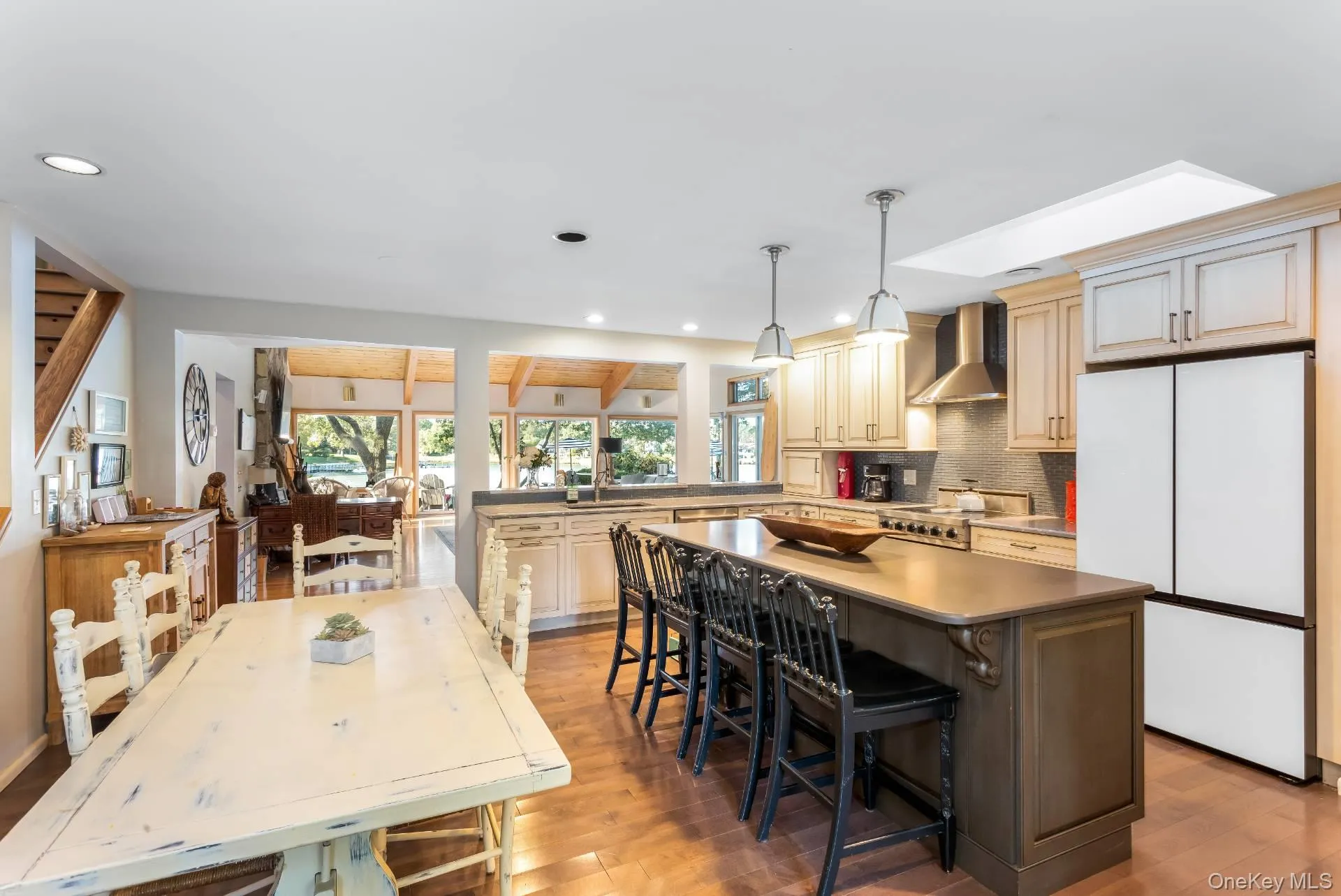 Kitchen with freestanding refrigerator, tasteful backsplash, light wood-type flooring, a kitchen island, and pendant lighting Kitchen with freestanding refrigerator, tasteful backsplash, light wood-type flooring, a kitchen island, and pendant lighting