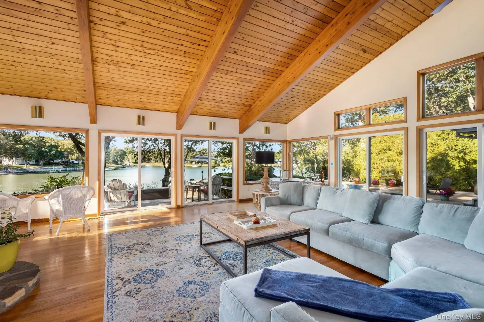 Living room featuring high vaulted ceiling, a wooden ceiling with exposed beams, and wood finished floors Living room featuring high vaulted ceiling, a wooden ceiling with exposed beams, and wood finished floors