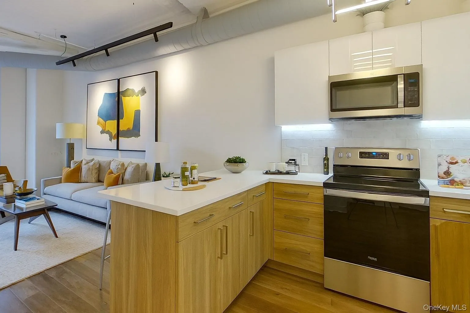 Kitchen with stainless steel appliances, light countertops, a peninsula, open floor plan, and tasteful backsplash Kitchen with stainless steel appliances, light countertops, a peninsula, open floor plan, and tasteful backsplash