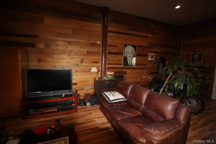 Living area featuring wooden walls and wood finished floors Living area featuring wooden walls and wood finished floors
