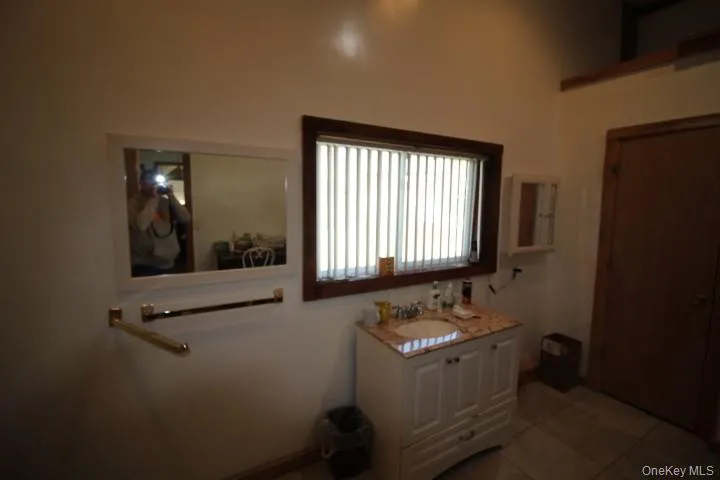 Bathroom with light tile patterned floors and vanity Bathroom with light tile patterned floors and vanity