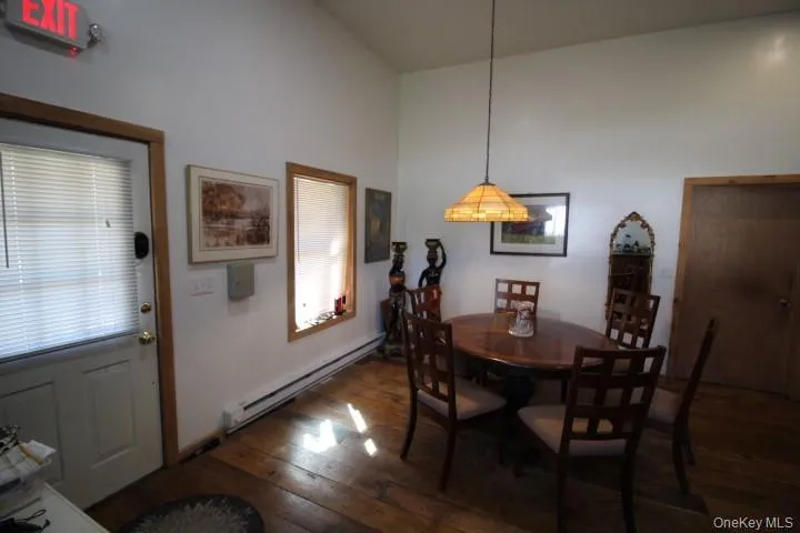 Dining space with a baseboard heating unit and dark wood-type flooring Dining space with a baseboard heating unit and dark wood-type flooring