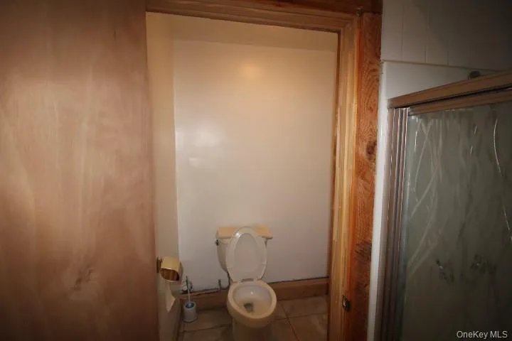 Bathroom featuring a shower stall and tile patterned floors Bathroom featuring a shower stall and tile patterned floors