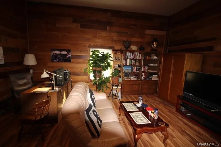 Living room with wood finished floors and wooden walls Living room with wood finished floors and wooden walls