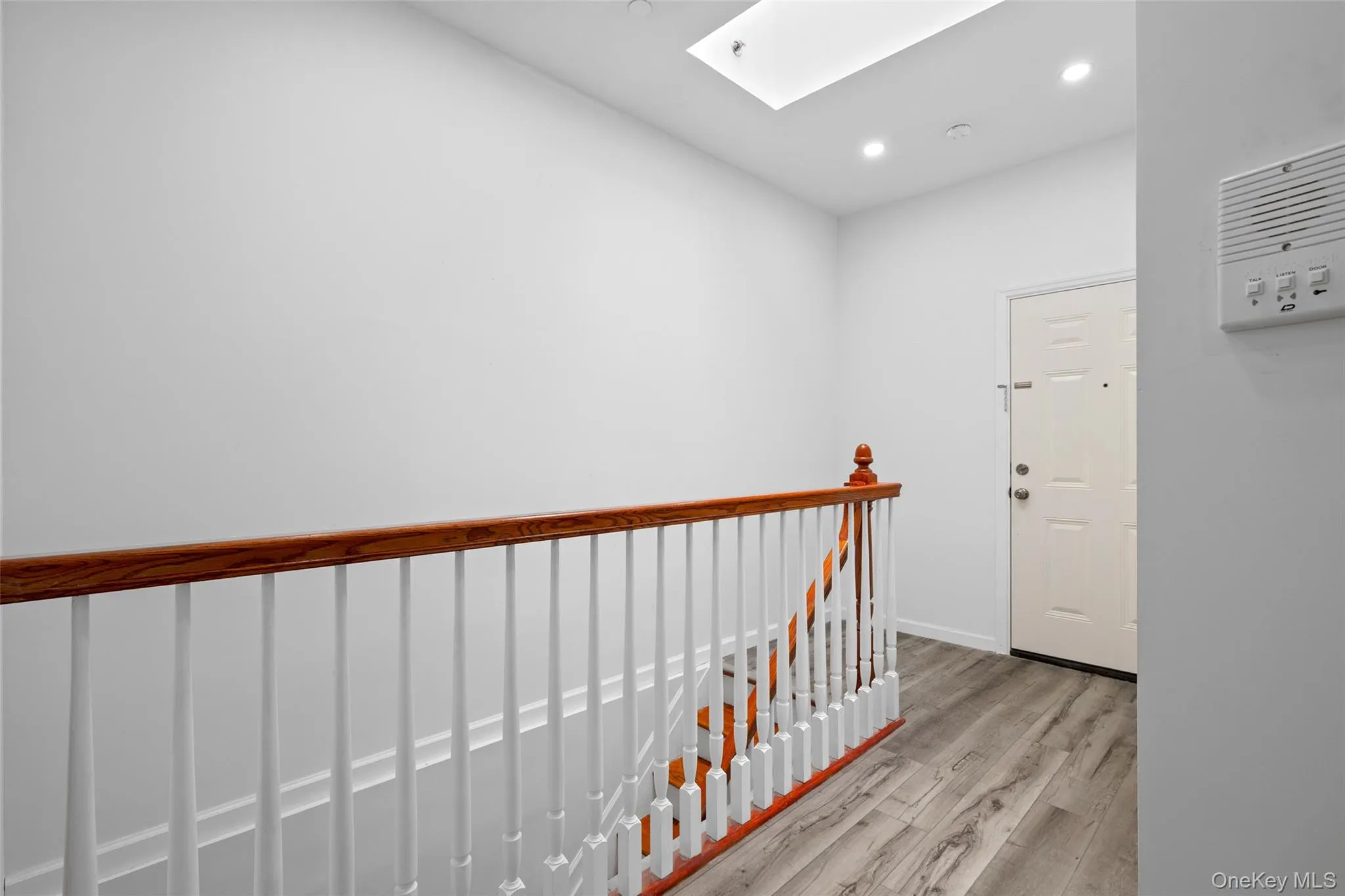 Hall with a skylight, an upstairs landing, light wood-type flooring, and recessed lighting Hall with a skylight, an upstairs landing, light wood-type flooring, and recessed lighting