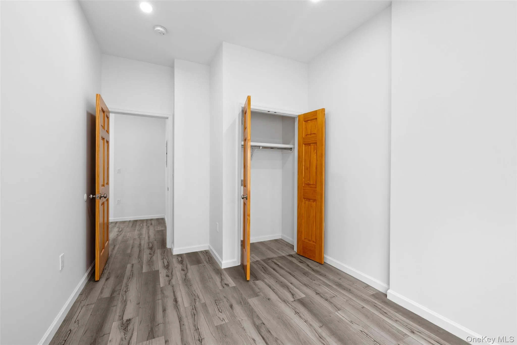Unfurnished bedroom featuring wood finished floors and a closet Unfurnished bedroom featuring wood finished floors and a closet