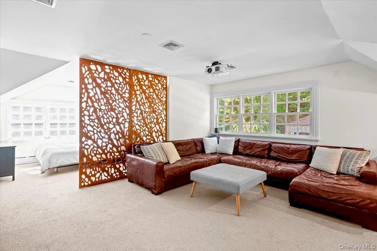 Living area with carpet floors and a baseboard heating unit Living area with carpet floors and a baseboard heating unit