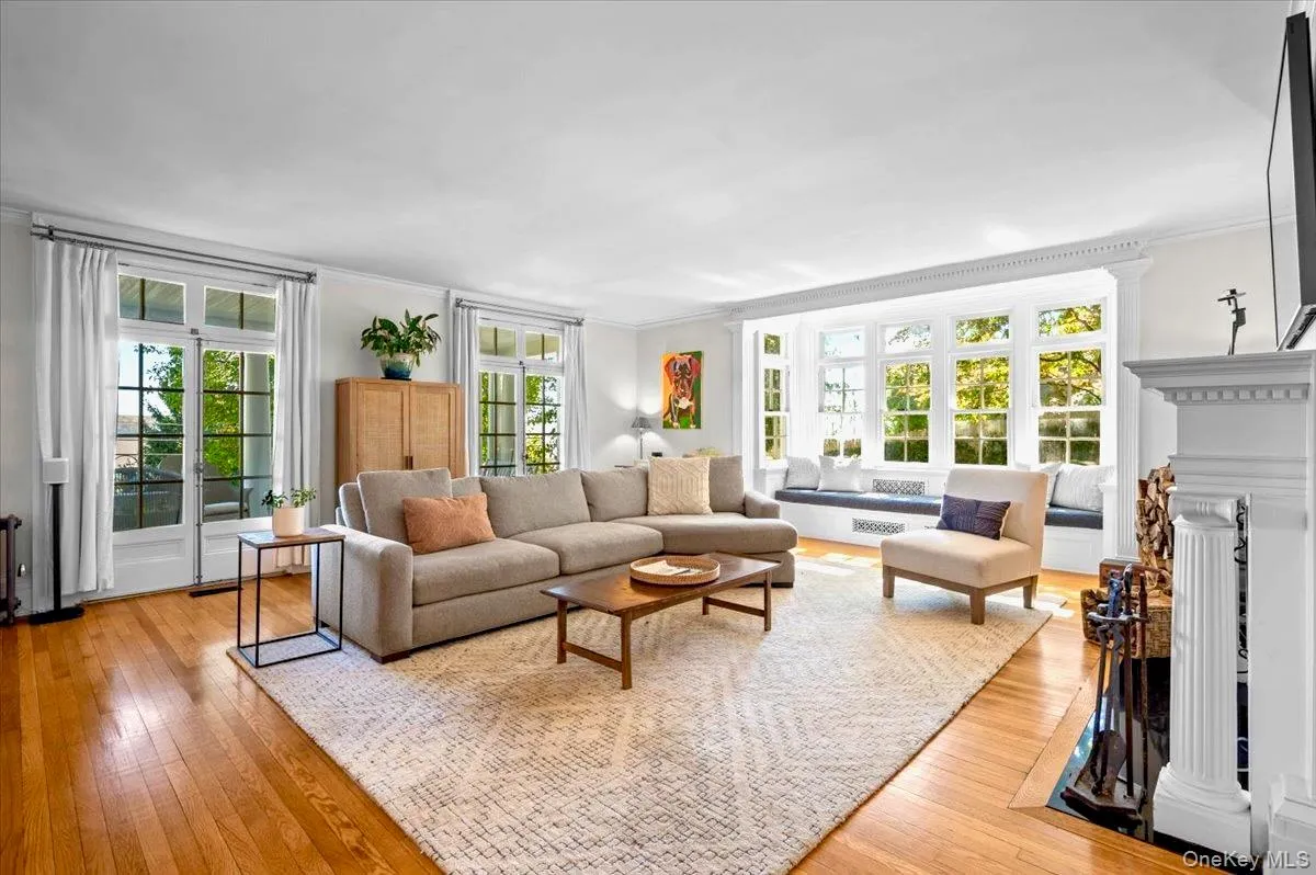 Living area with a fireplace, light wood finished floors, and ornamental molding Living area with a fireplace, light wood finished floors, and ornamental molding