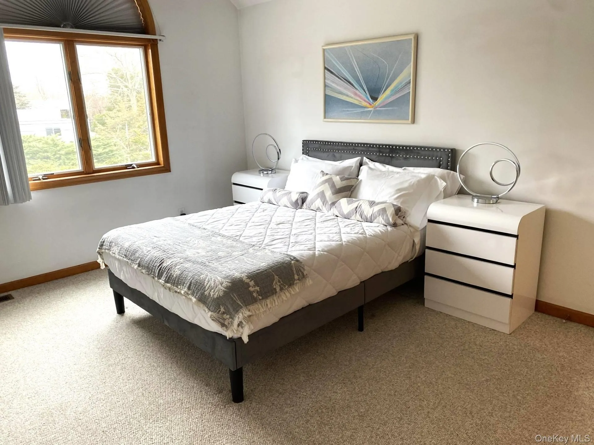 Bedroom with baseboards and light carpet Bedroom with baseboards and light carpet