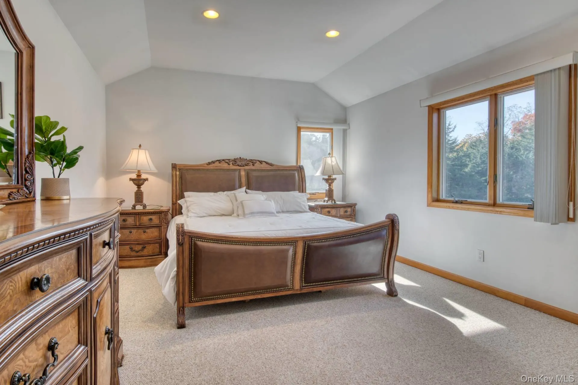Bedroom with light colored carpet, multiple windows, lofted ceiling, and recessed lighting Bedroom with light colored carpet, multiple windows, lofted ceiling, and recessed lighting