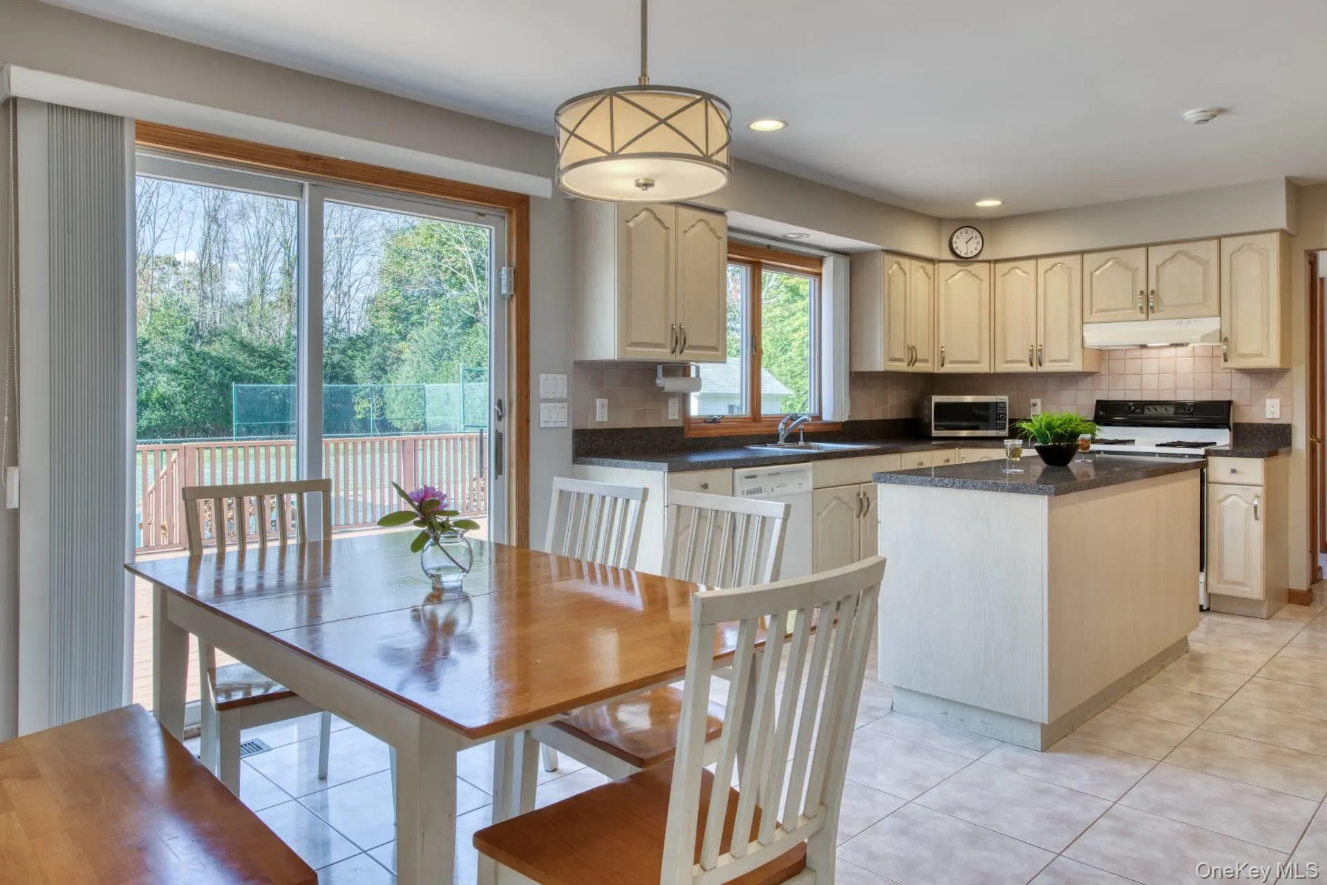 Kitchen featuring hanging light fixtures, backsplash, range with electric cooktop, under cabinet range hood, and recessed lighting Kitchen featuring hanging light fixtures, backsplash, range with electric cooktop, under cabinet range hood, and recessed lighting