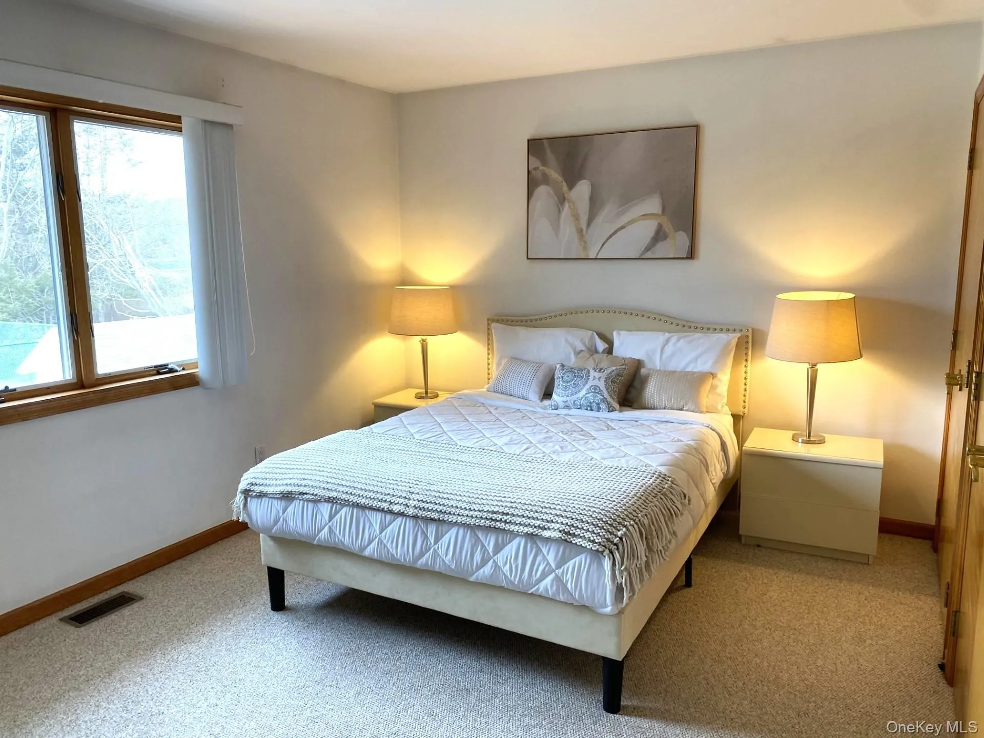 Bedroom with light colored carpet and baseboards Bedroom with light colored carpet and baseboards