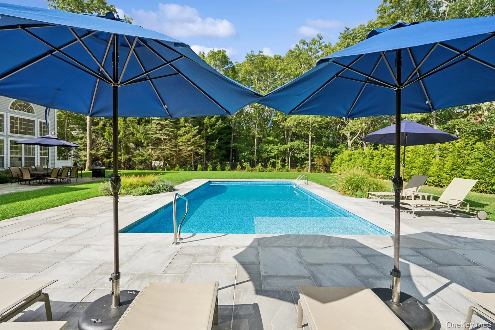 Outdoor pool featuring a patio area, a lawn, and outdoor dining area Outdoor pool featuring a patio area, a lawn, and outdoor dining area