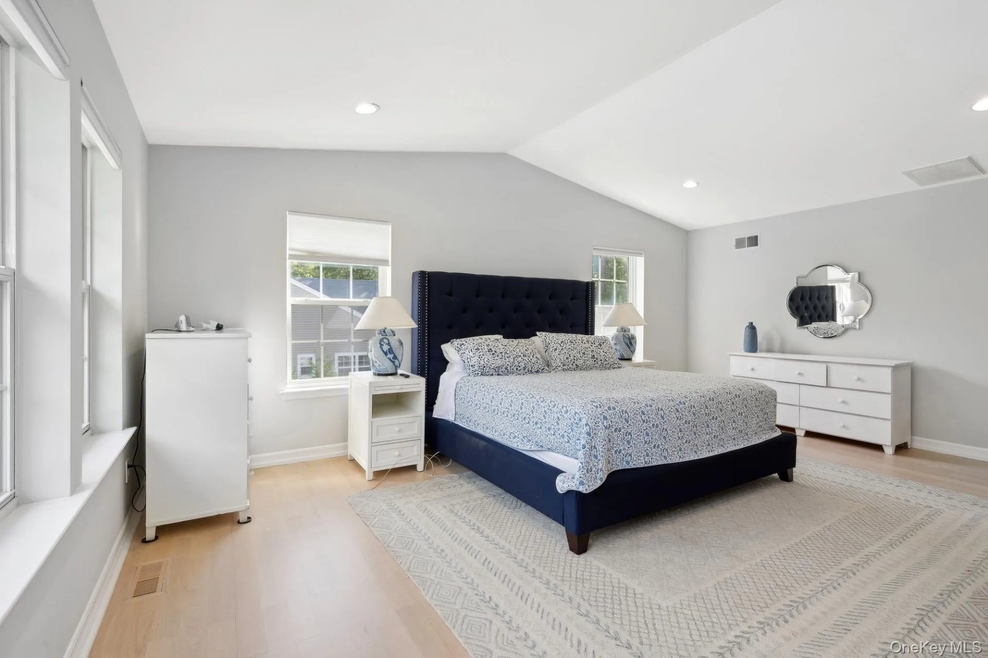 Bedroom featuring light wood-style flooring, vaulted ceiling, and recessed lighting Bedroom featuring light wood-style flooring, vaulted ceiling, and recessed lighting