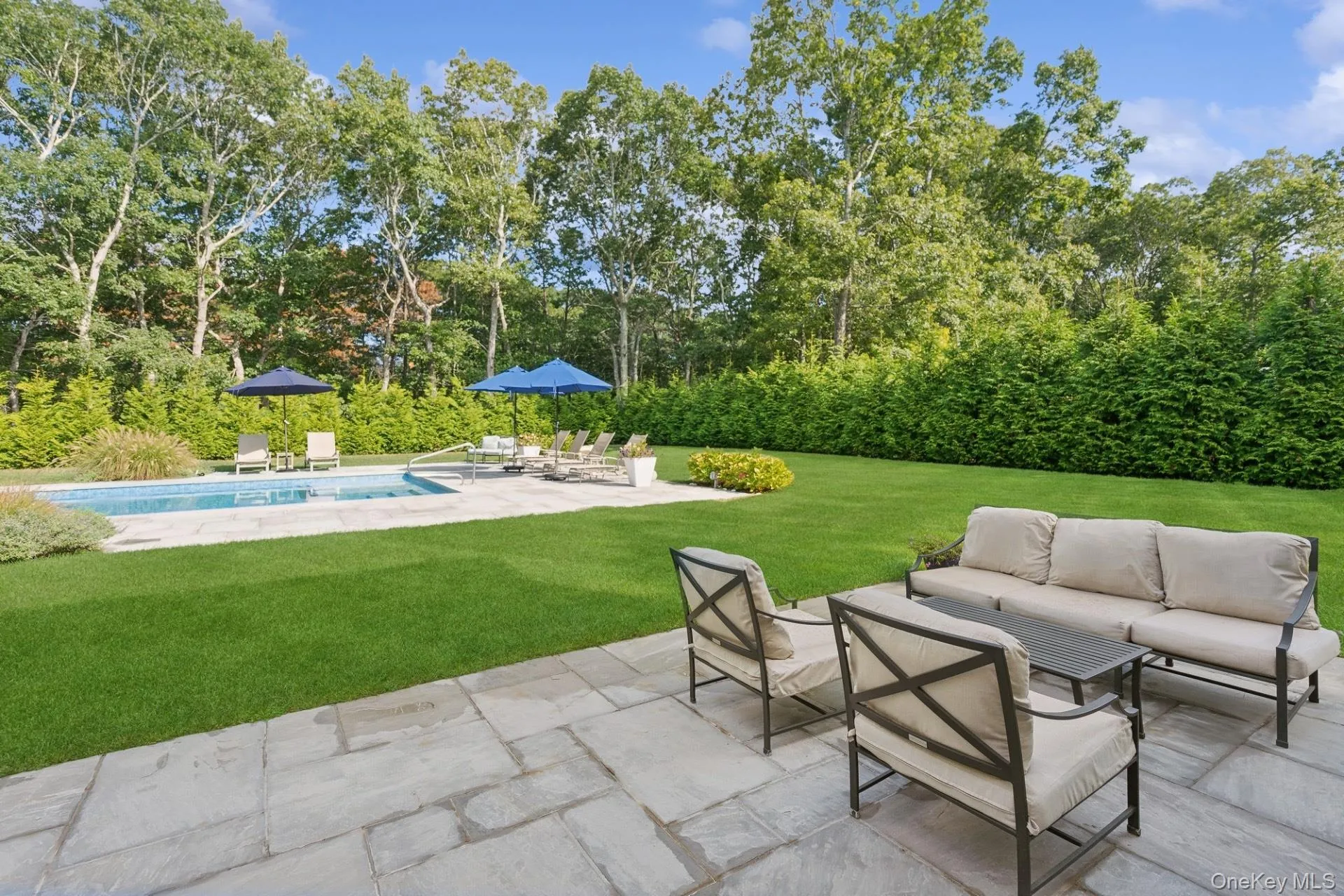 View of patio / terrace featuring outdoor lounge area, an outdoor pool, and view of scattered trees View of patio / terrace featuring outdoor lounge area, an outdoor pool, and view of scattered trees
