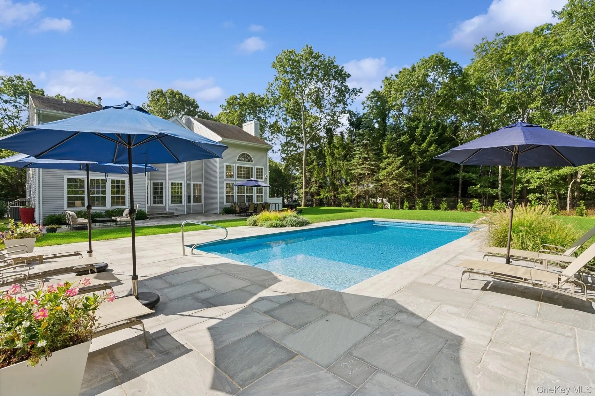 Outdoor pool with a patio and a lawn Outdoor pool with a patio and a lawn