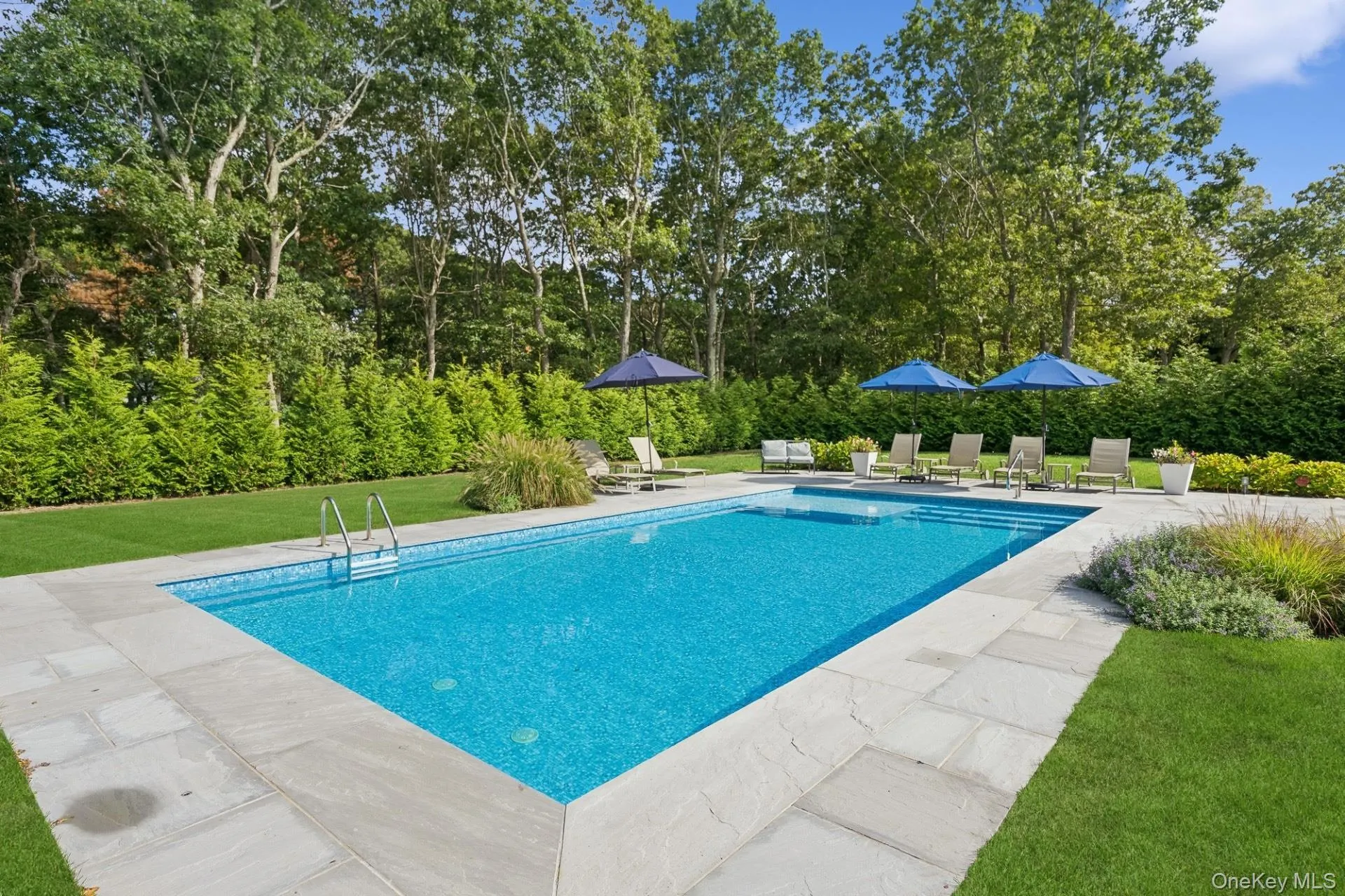 Swimming pool with a yard and a patio area Swimming pool with a yard and a patio area