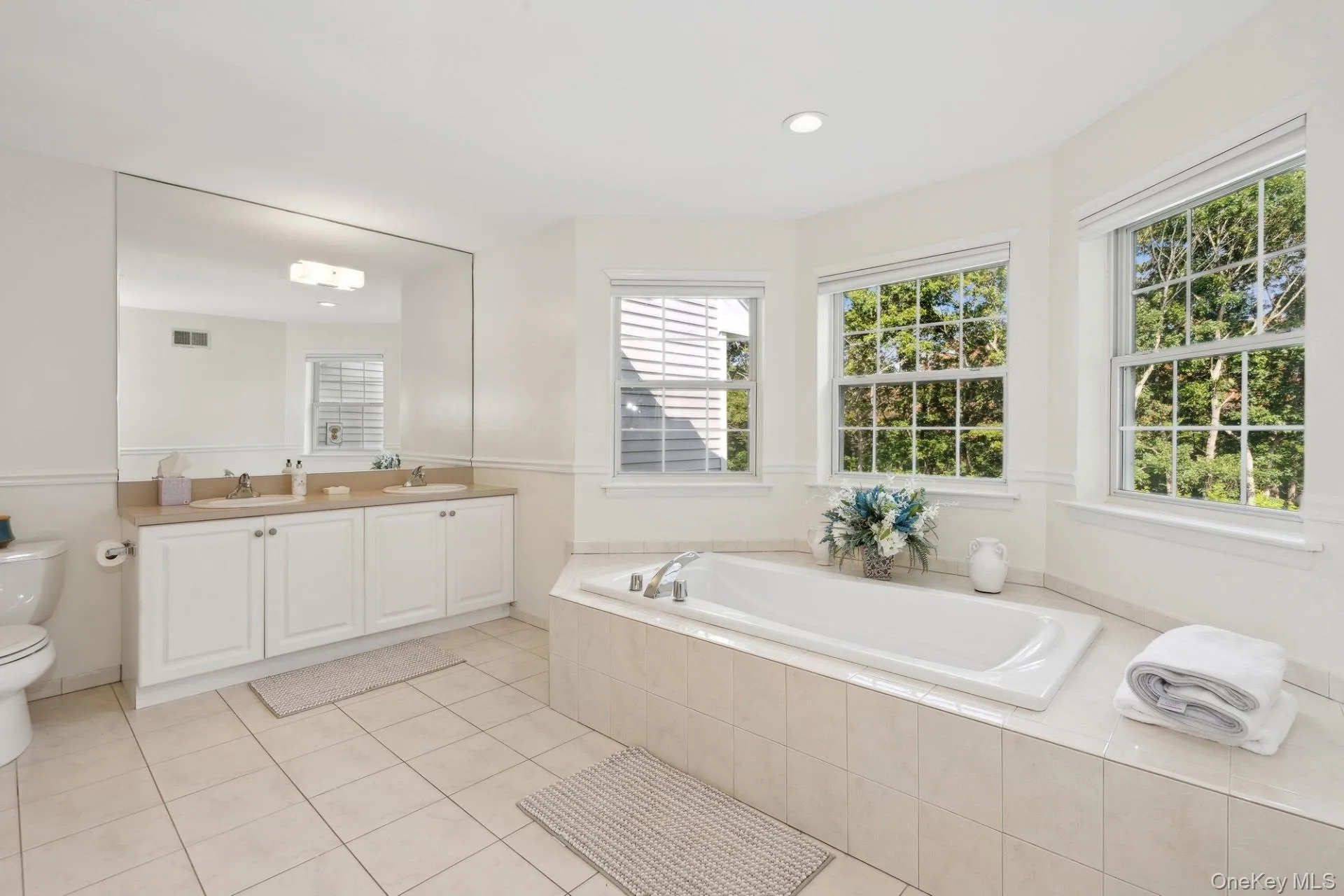 Bathroom featuring a bath, double vanity, light tile patterned flooring, and recessed lighting Bathroom featuring a bath, double vanity, light tile patterned flooring, and recessed lighting