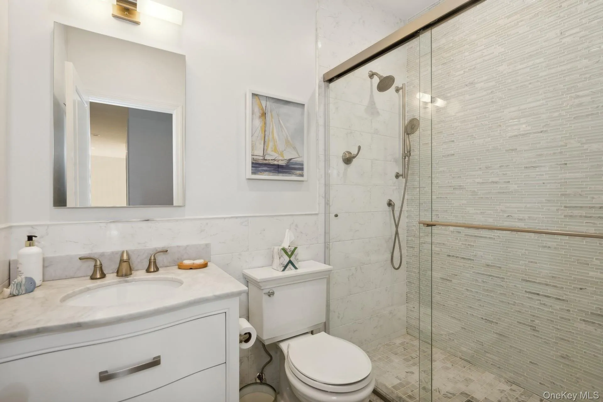 Full bathroom featuring vanity, a shower stall, tile walls, and wainscoting Full bathroom featuring vanity, a shower stall, tile walls, and wainscoting