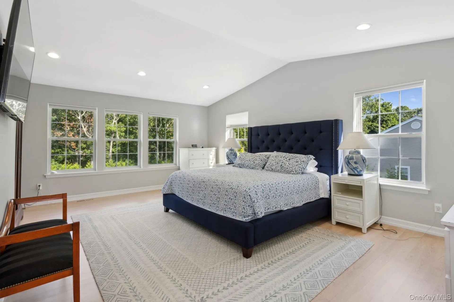 Bedroom featuring light wood-type flooring, recessed lighting, and vaulted ceiling Bedroom featuring light wood-type flooring, recessed lighting, and vaulted ceiling
