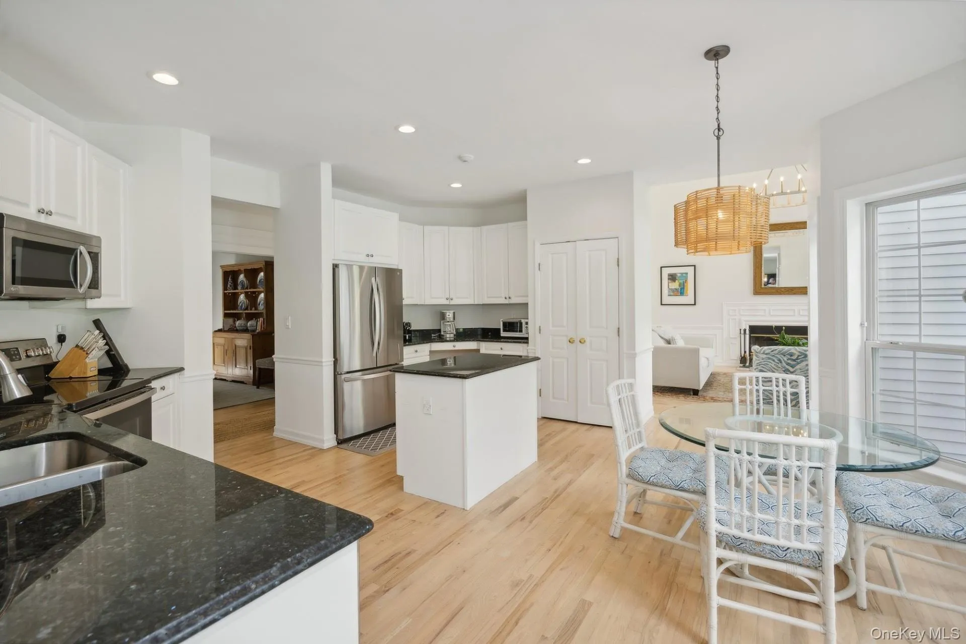 Kitchen with white cabinets, appliances with stainless steel finishes, light wood-style flooring, decorative light fixtures, and recessed lighting Kitchen with white cabinets, appliances with stainless steel finishes, light wood-style flooring, decorative light fixtures, and recessed lighting