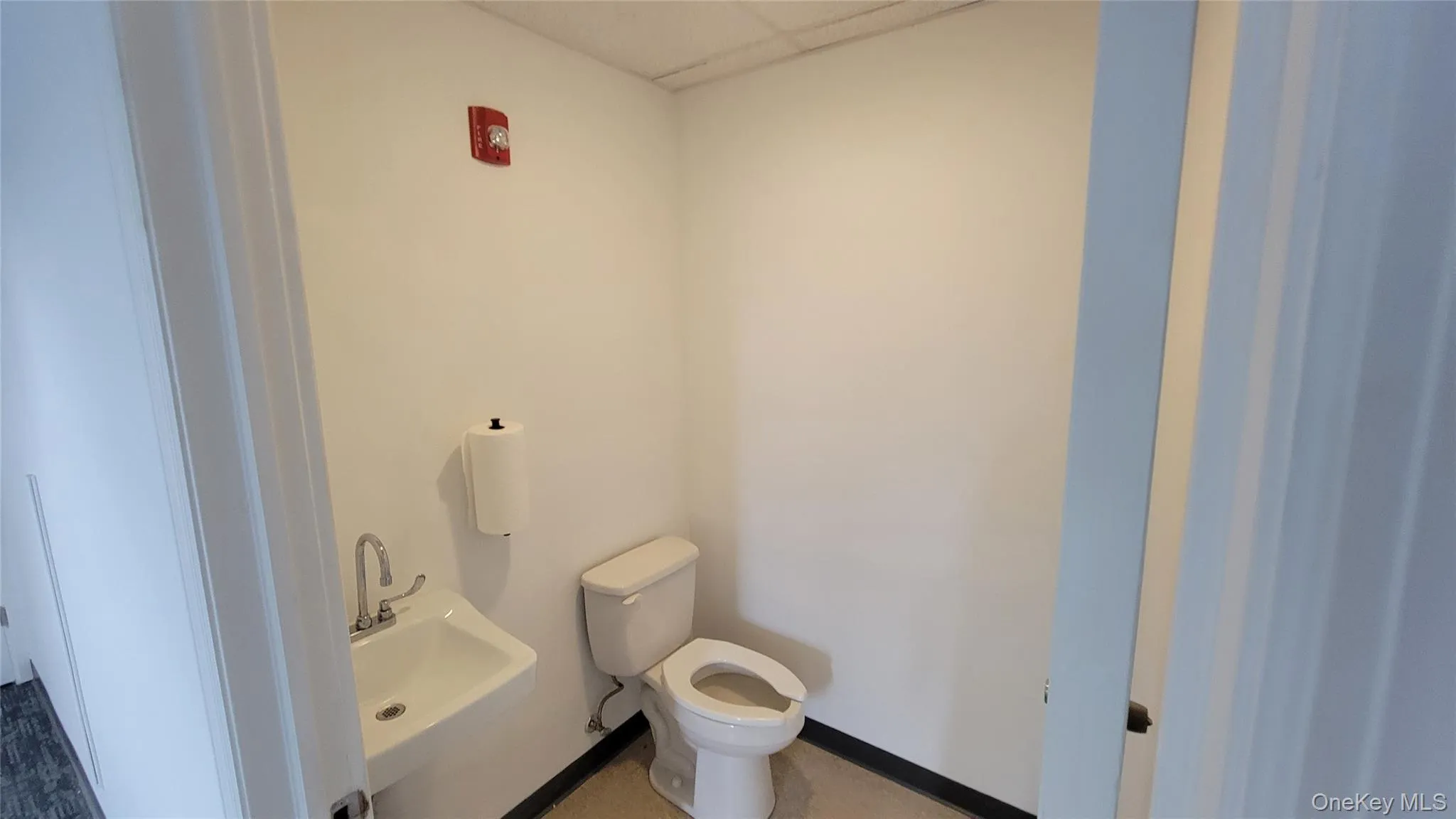 Bathroom featuring a drop ceiling and toilet Bathroom featuring a drop ceiling and toilet