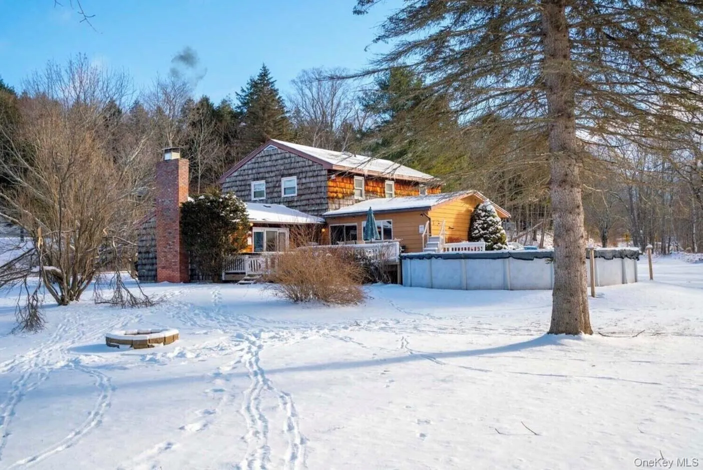 Snow covered rear of property with a chimney Snow covered rear of property with a chimney