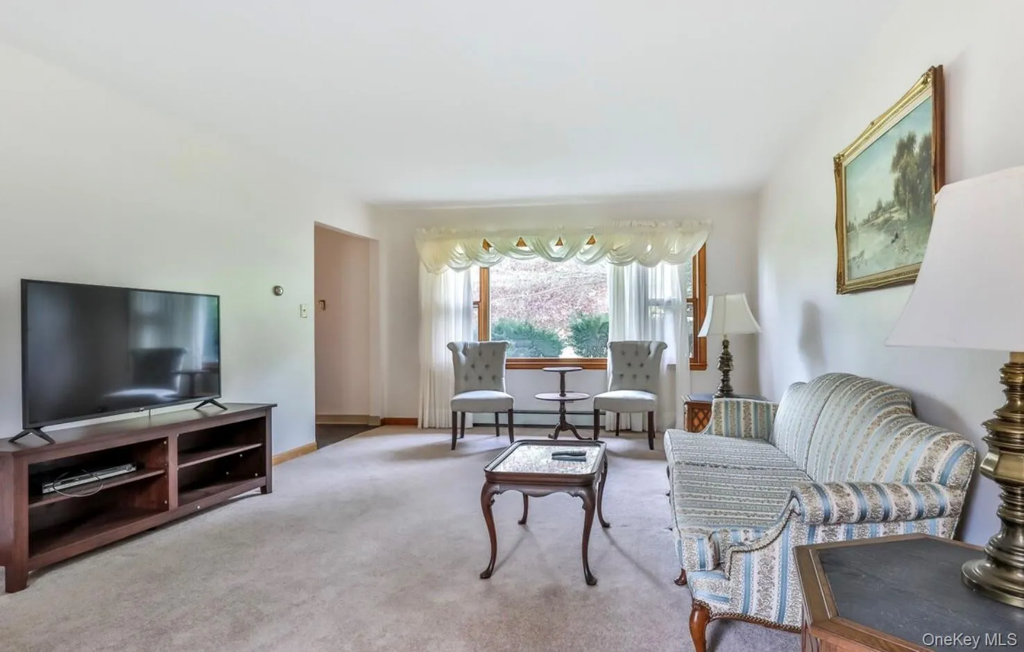 Carpeted living area featuring baseboards Carpeted living area featuring baseboards
