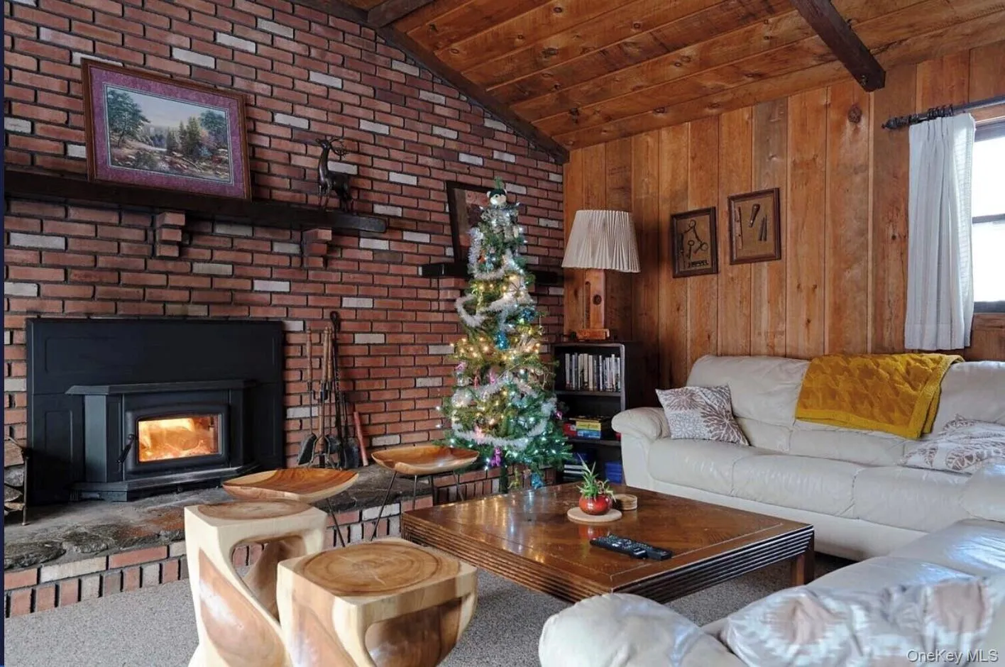 Carpeted living area featuring wooden ceiling and wood walls Carpeted living area featuring wooden ceiling and wood walls