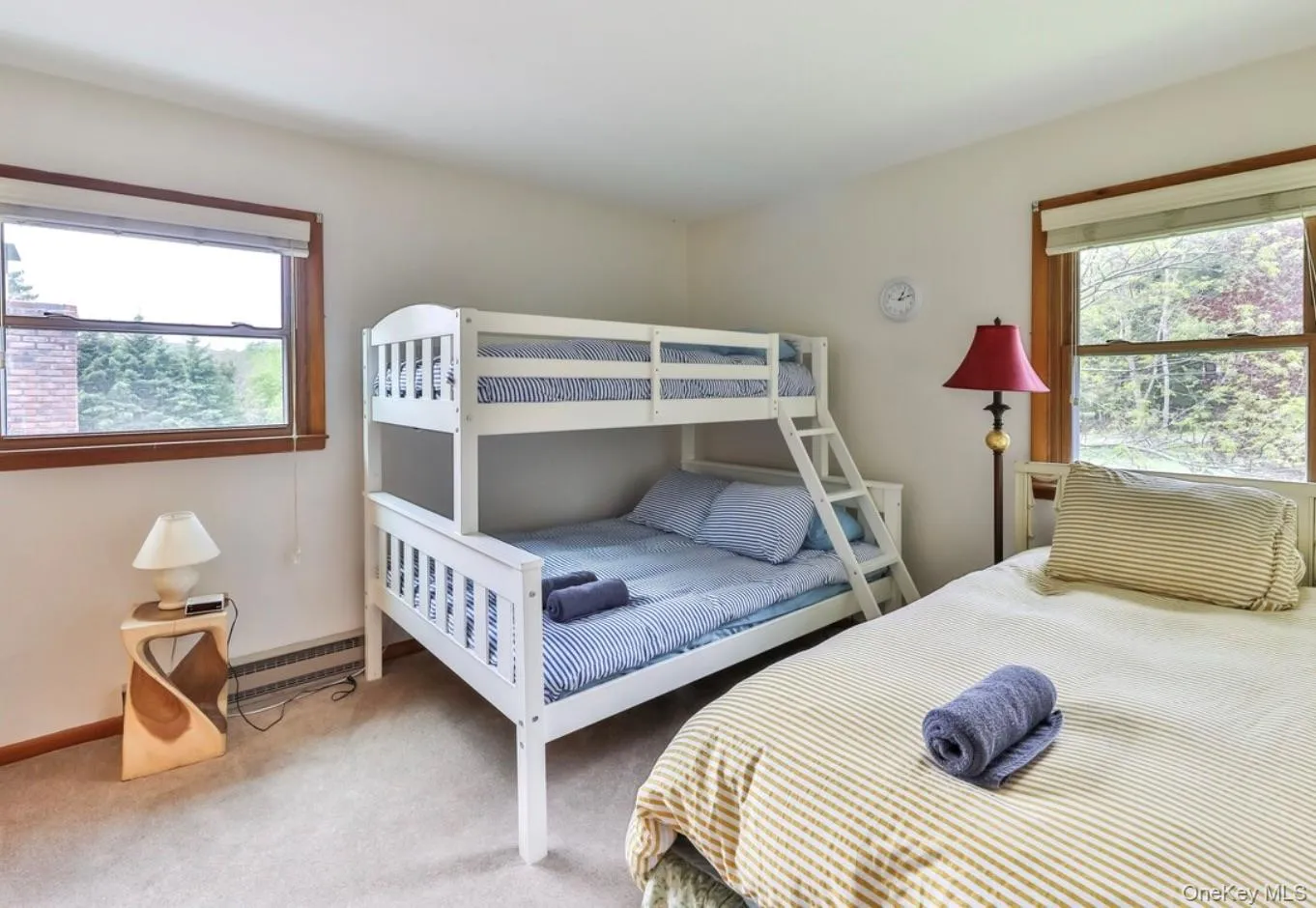 Carpeted bedroom featuring baseboard heating and baseboards Carpeted bedroom featuring baseboard heating and baseboards