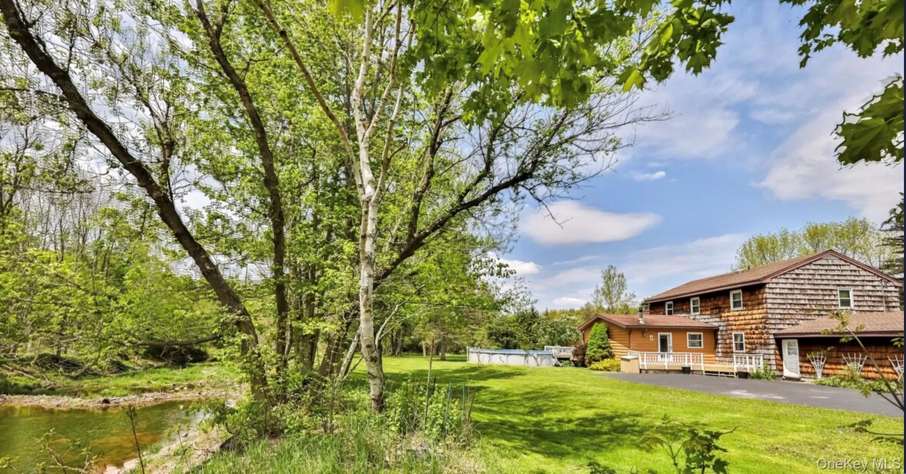 View of green lawn featuring a water view and a swimming pool View of green lawn featuring a water view and a swimming pool