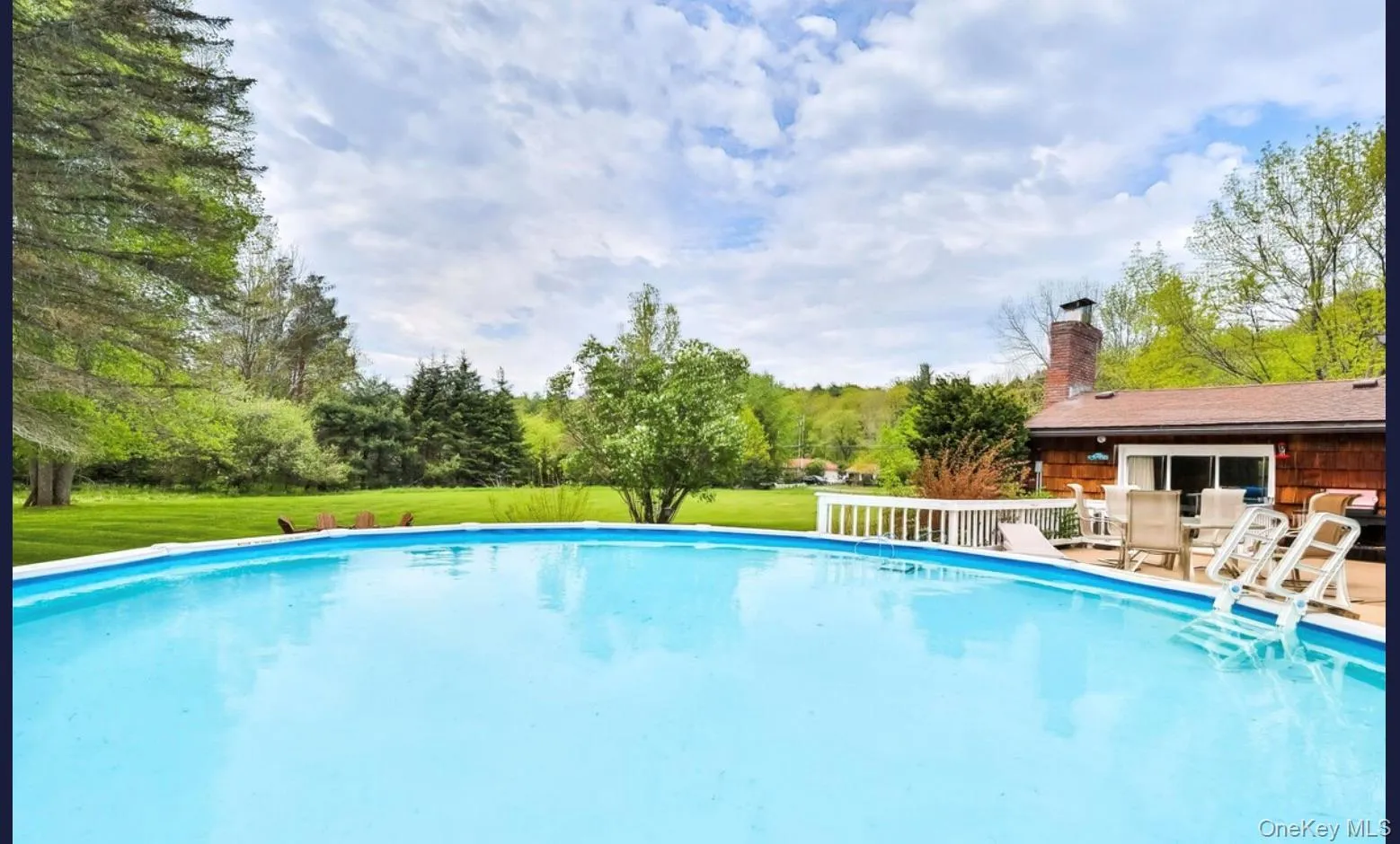 Outdoor pool with a patio and a lawn Outdoor pool with a patio and a lawn