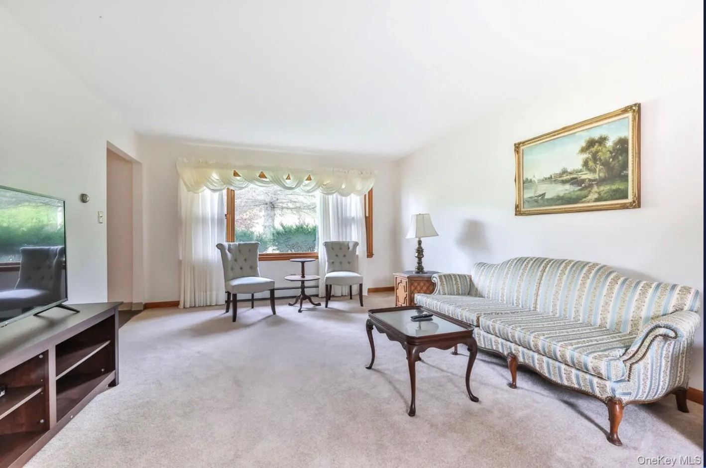 Carpeted living area featuring baseboards Carpeted living area featuring baseboards