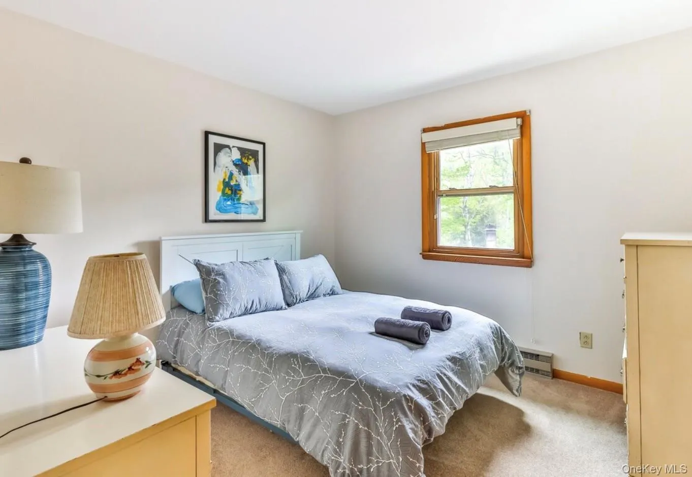Bedroom featuring carpet and a baseboard heating unit Bedroom featuring carpet and a baseboard heating unit