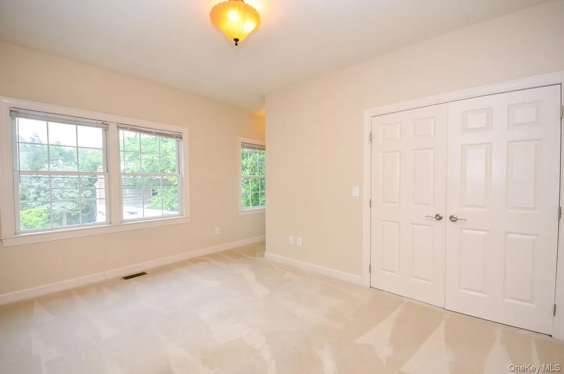 Unfurnished bedroom featuring light colored carpet and a closet Unfurnished bedroom featuring light colored carpet and a closet